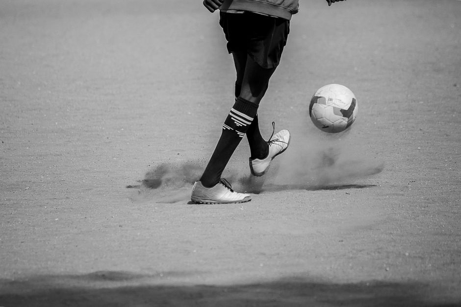 Dynamic black and white photo capturing a soccer player's skill and movement with a ball.