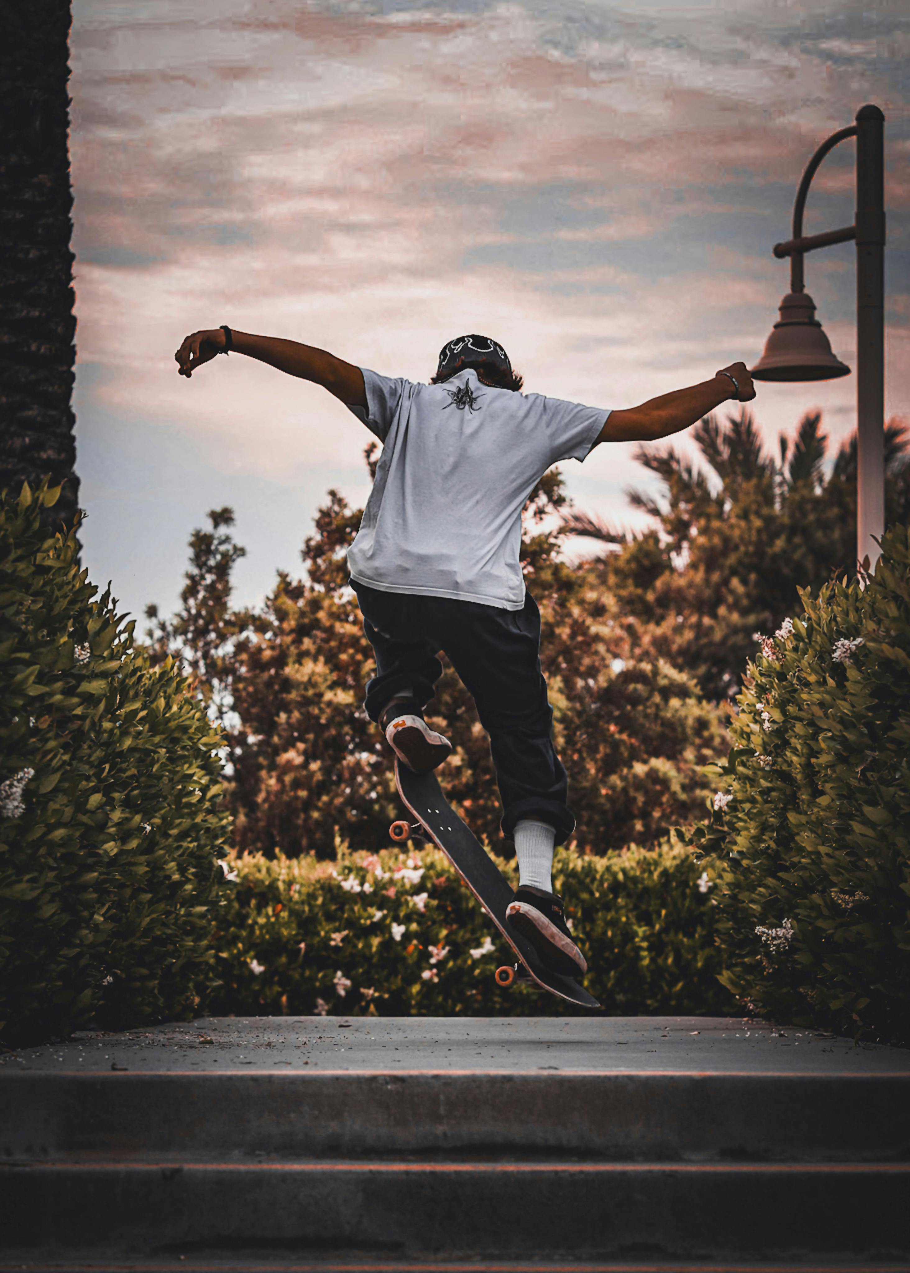 gratis Dynamische opname van een skateboarder die een truc in de lucht uitvoert in een openluchtpark. Stockfoto