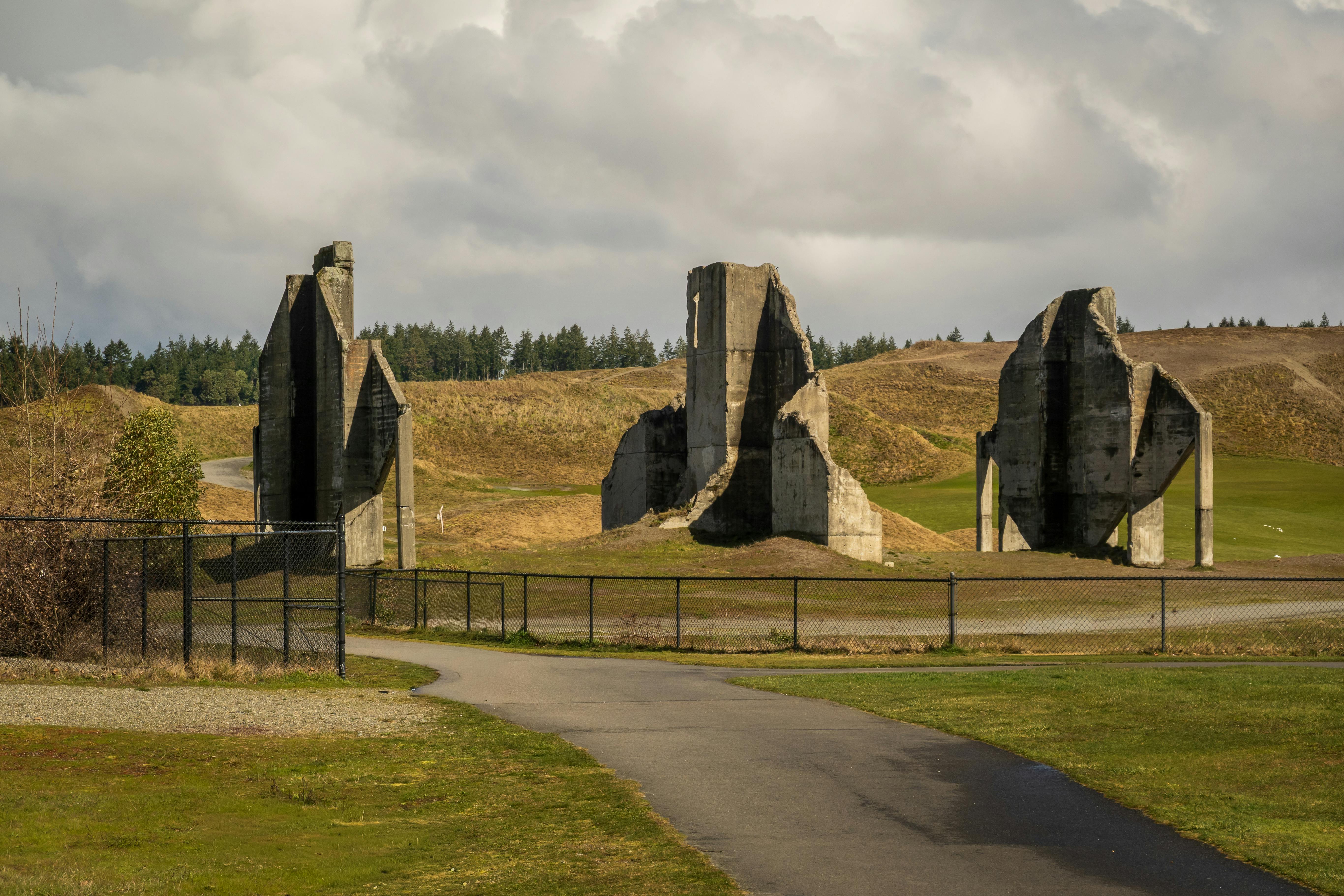 Gratis Majestuosas ruinas de hormigón en un campo abierto bajo un cielo nublado. Foto de stock