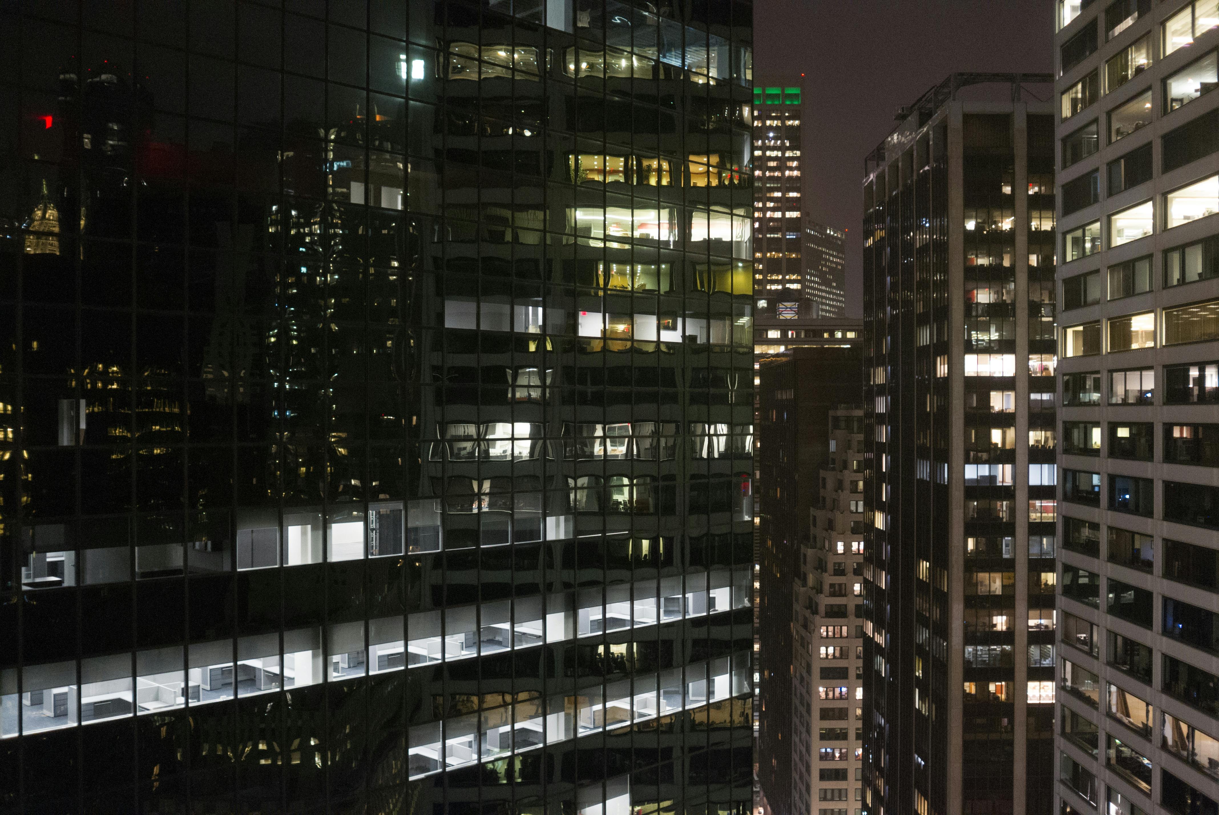 bezplatná Snímek osvětlených mrakodrapů v centru New Yorku v noci, ukazující městskou architekturu. Základová fotografie