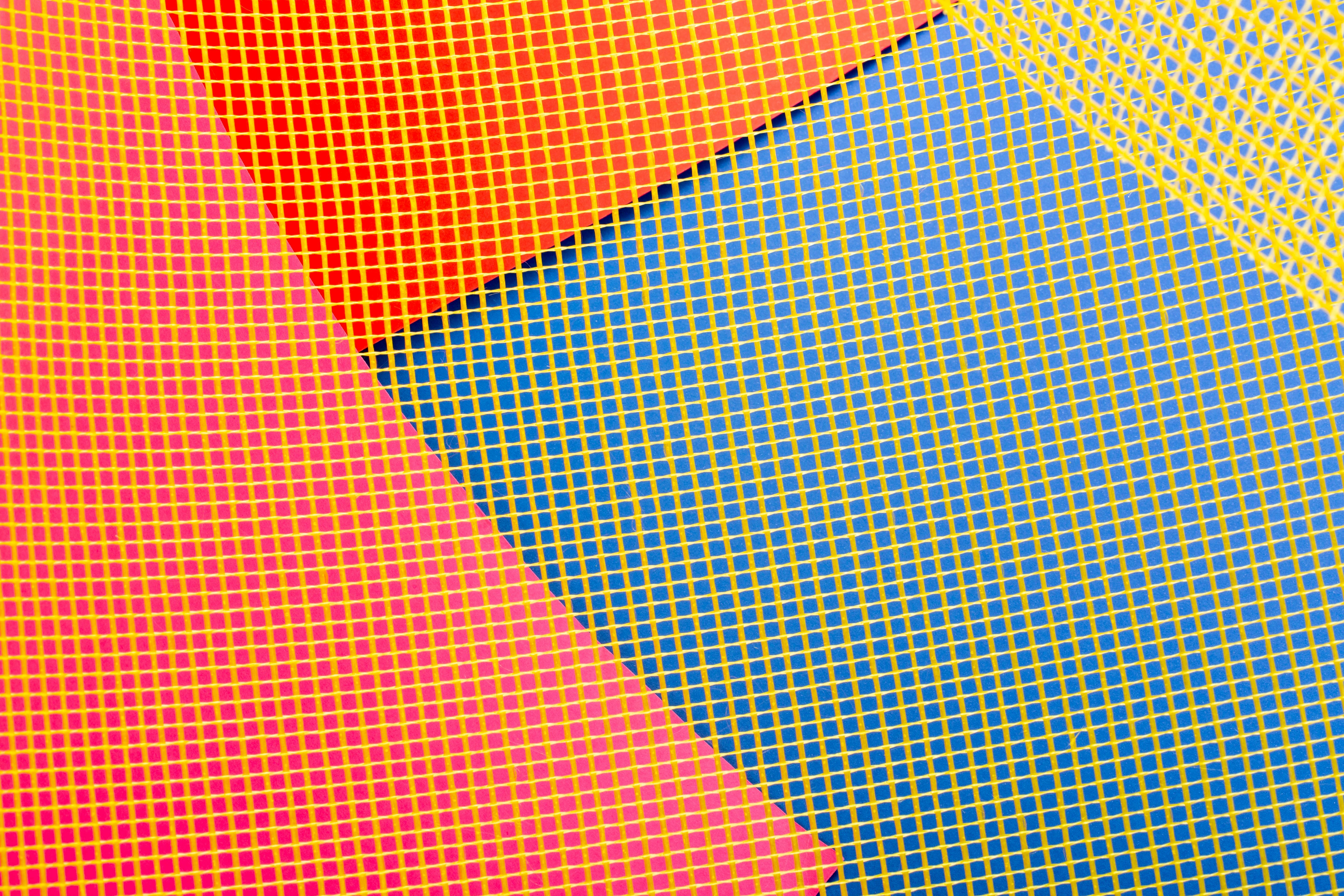 Vibrant abstract geometric pattern with colorful grids in red, pink, blue, and yellow.