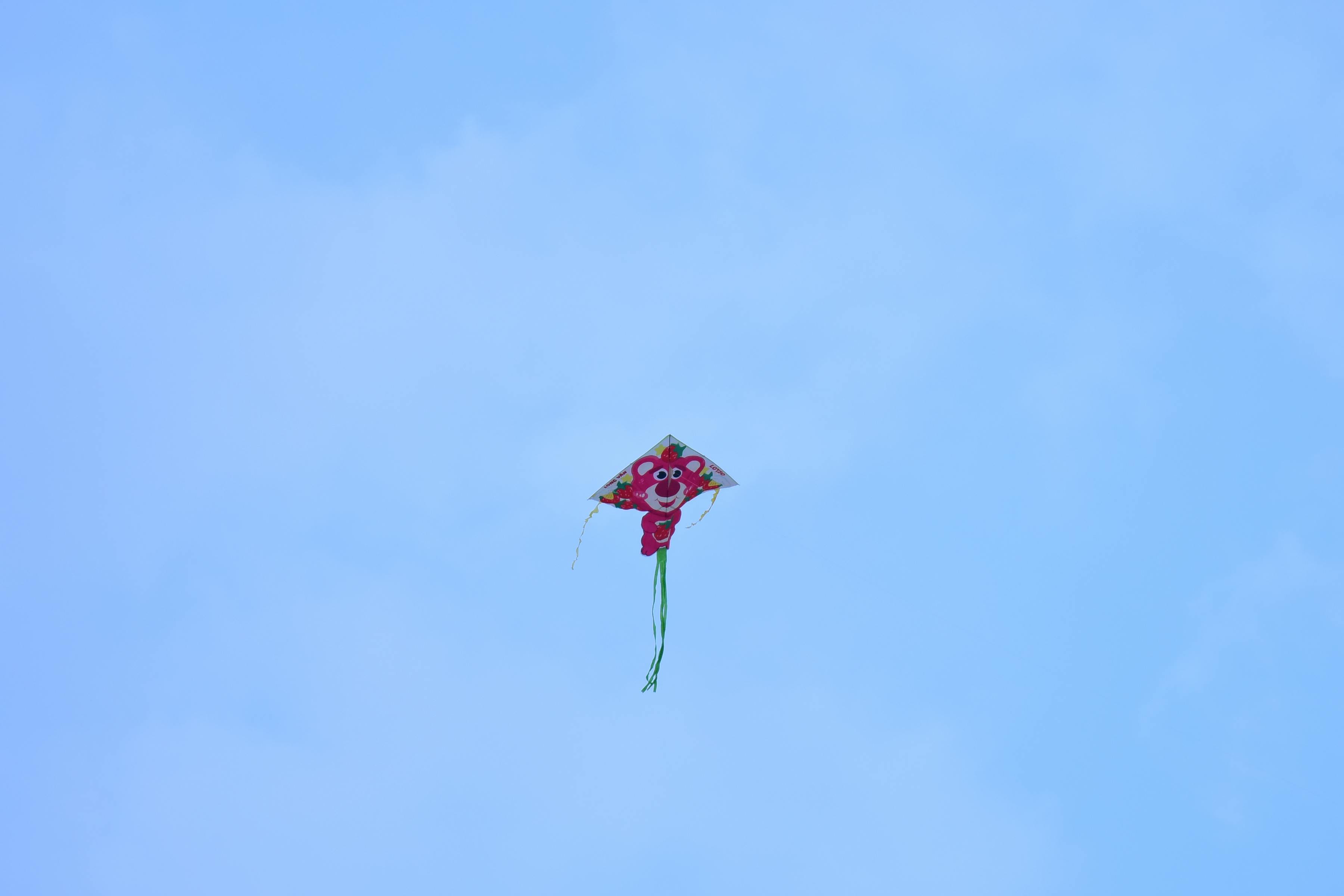 ingyenes Egyetlen élénk színű, vidám arcú sárkány száll a tiszta kék ég előtt, a szabadságot szimbolizálva. Stockfotó