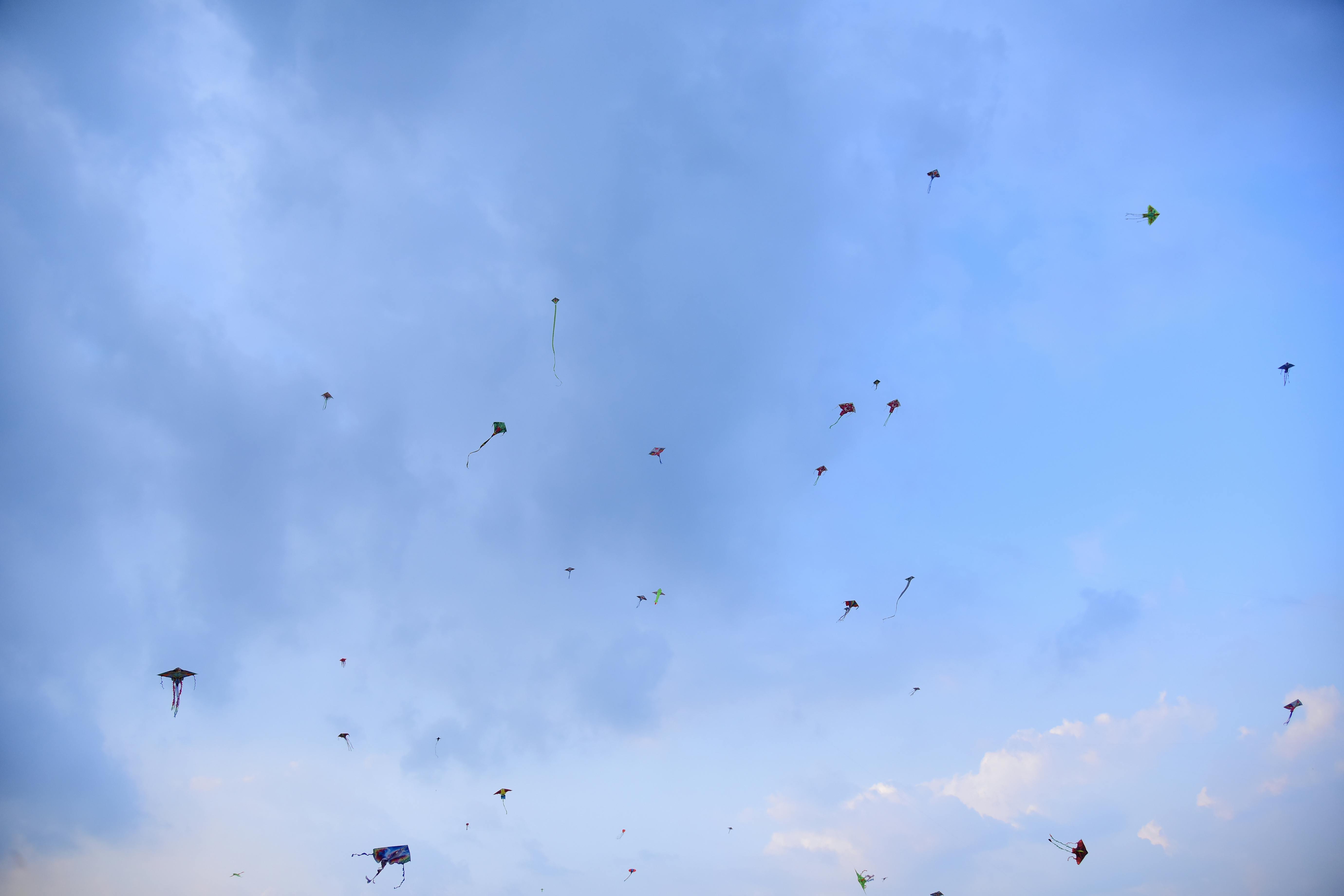 Безкоштовне Яскраві повітряні змії злітають високо в чистому блакитному небі, створюючи радісну та святкову атмосферу. стокове фото