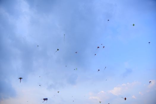 Vibrant kites soar high in a clear blue sky, showcasing a joyful and festive atmosphere.