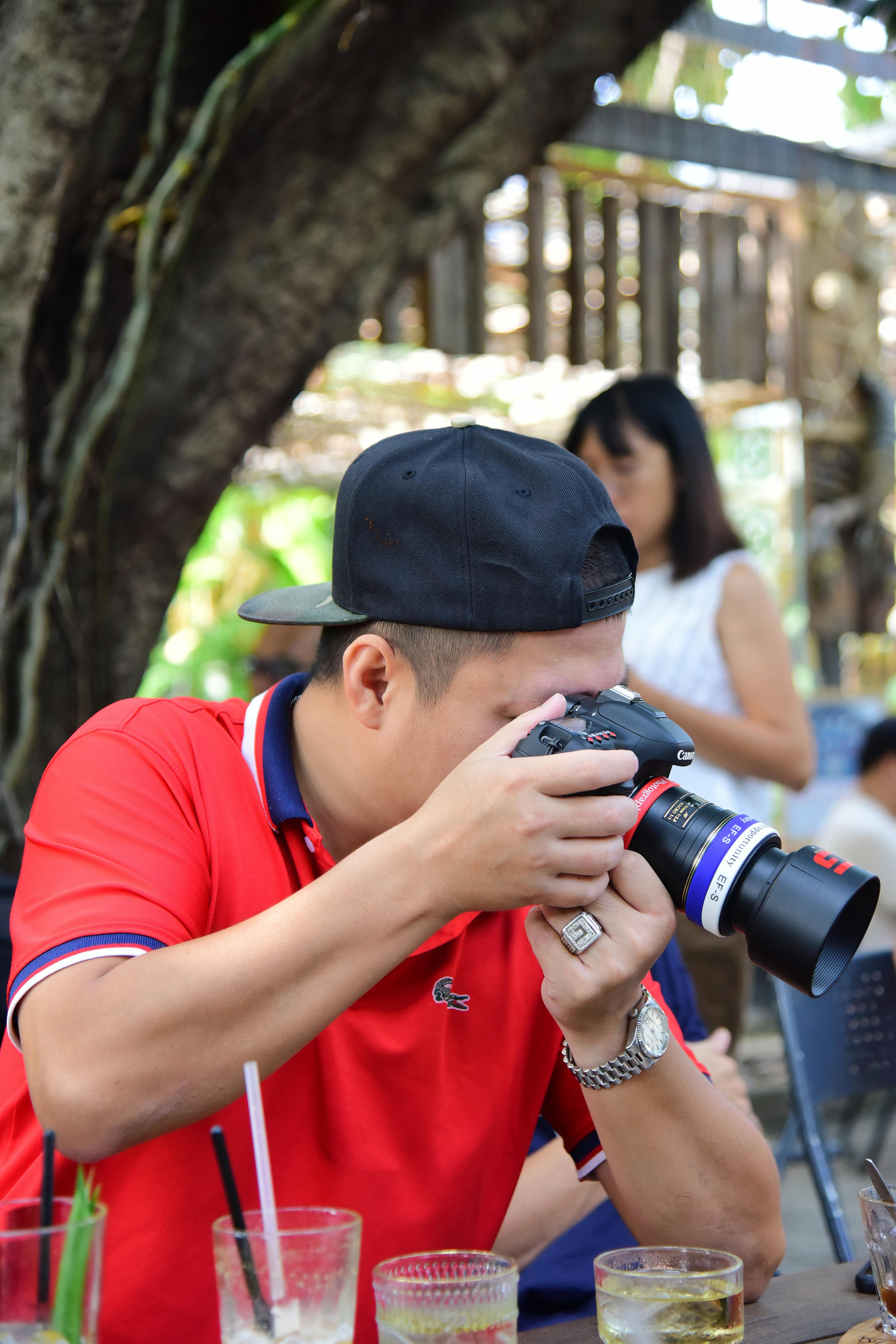 무료 한 남성이 DSLR 카메라를 사용하여 야외에서 사진을 찍으며 생생한 순간들을 정밀하게 포착하고 있다. 스톡 사진