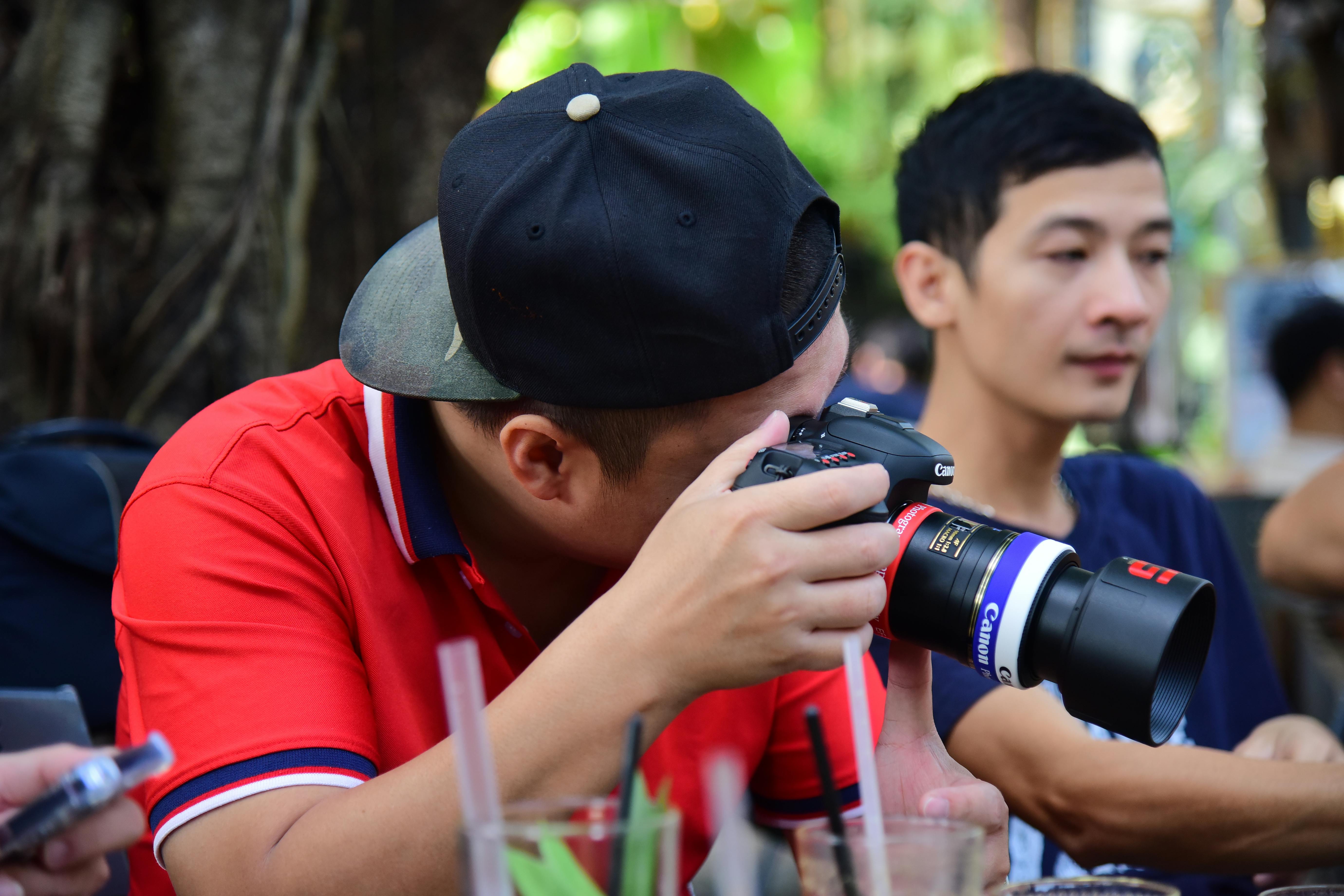 Gratis Fotógrafo en un entorno informal al aire libre tomando fotos con una cámara réflex digital. Foto de stock