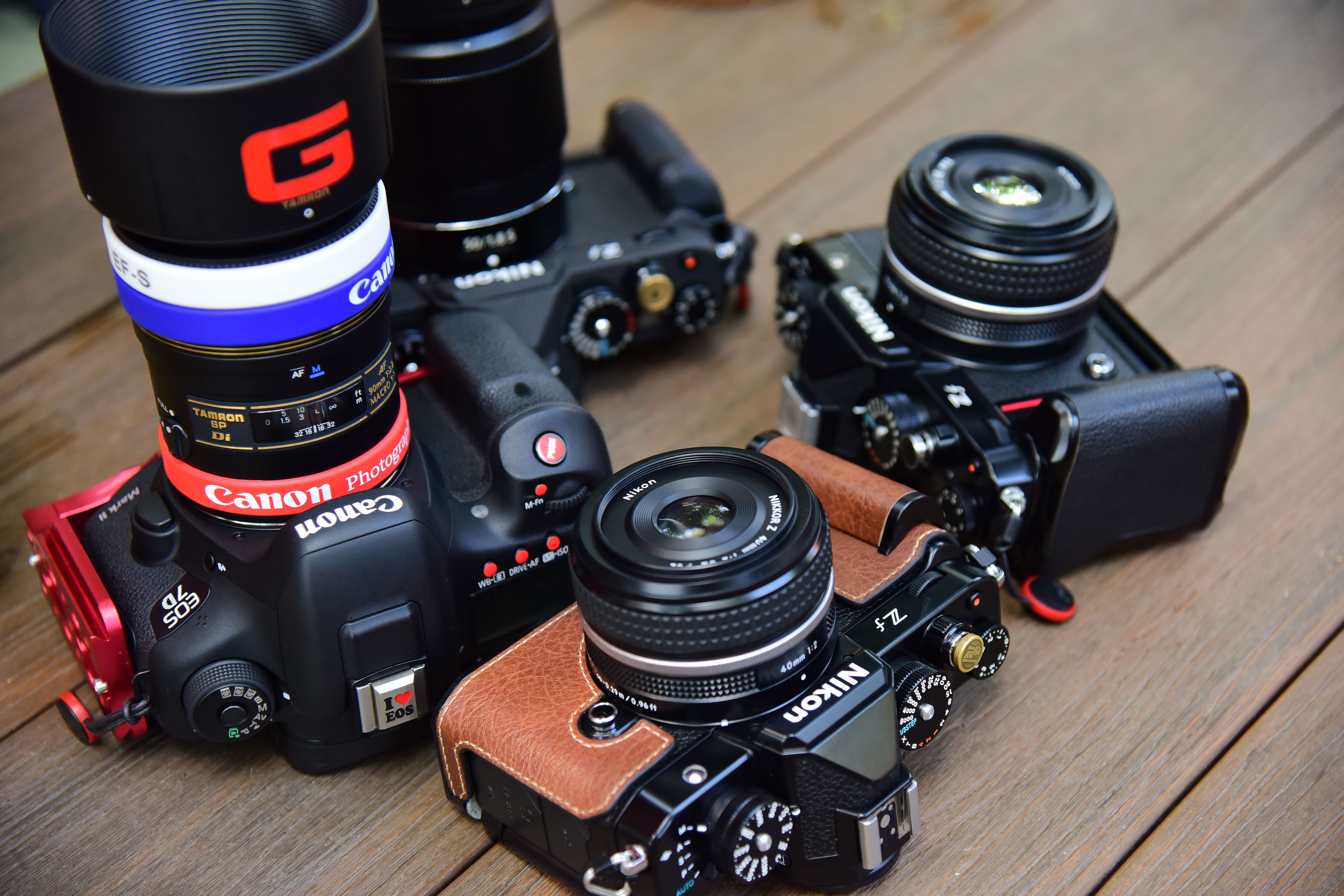 A close-up shot showcasing various vintage and modern cameras on a wooden background.