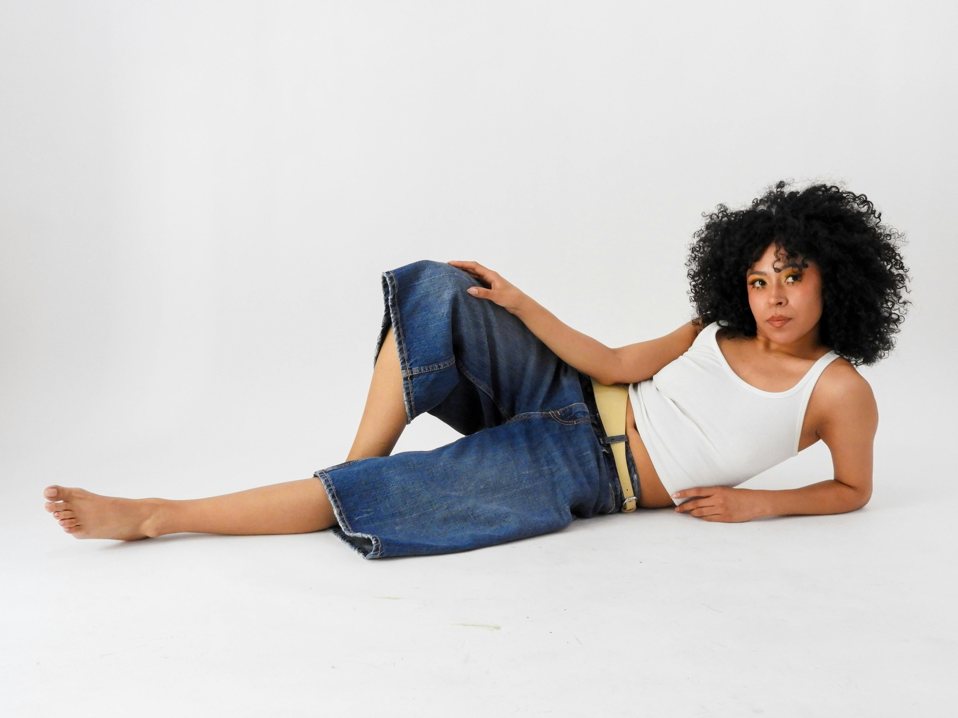 бесплатная Женщина в повседневной одежде позирует на белом студийном фоне. Стоковое фото