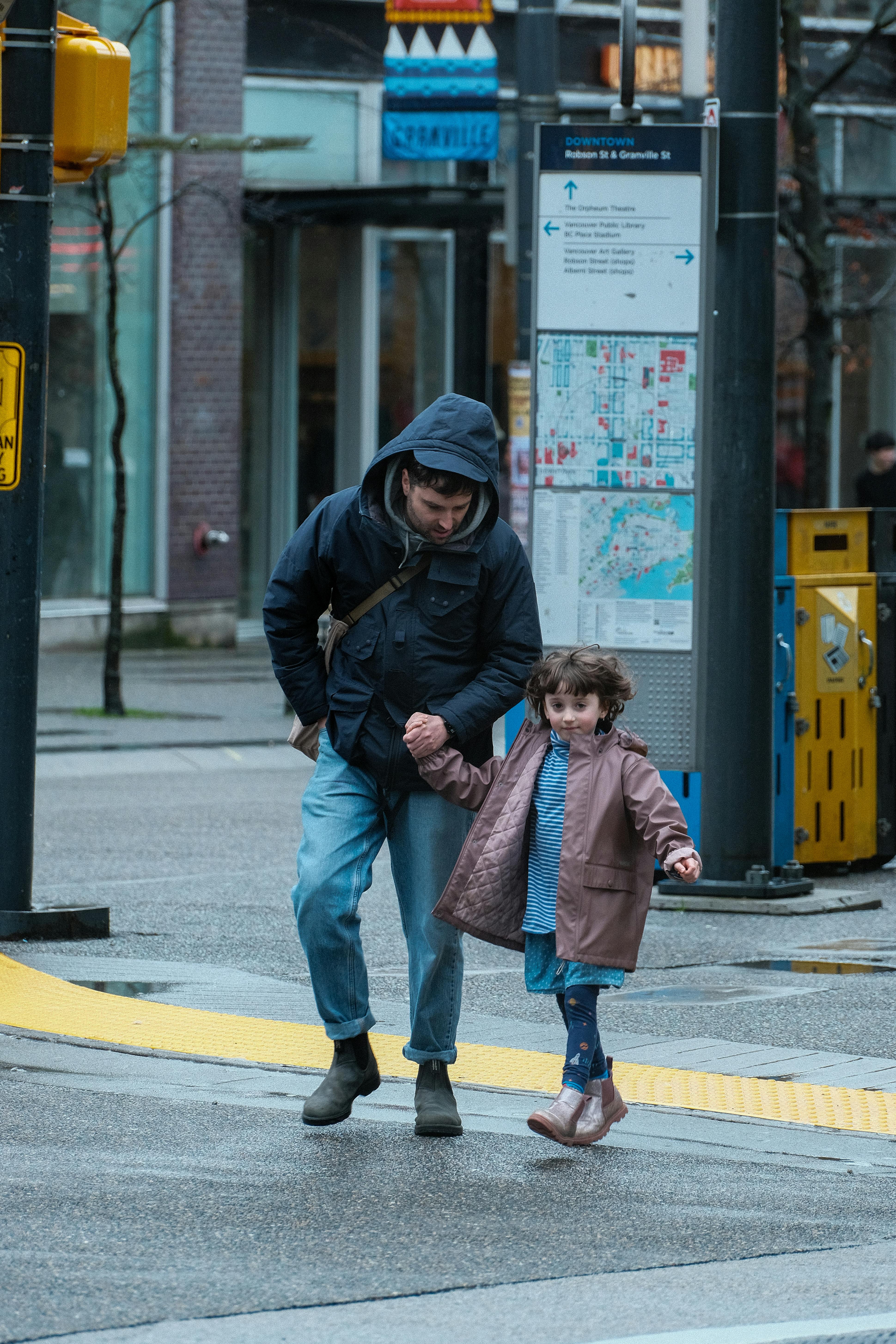 Miễn phí Cha và con gái nắm tay nhau đi dạo trên đường phố vào một ngày nhiều mây. Ảnh lưu trữ