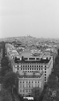 A stunning black and white aerial photo of Paris featuring the Sacré-Cœur Basilica in the distance.