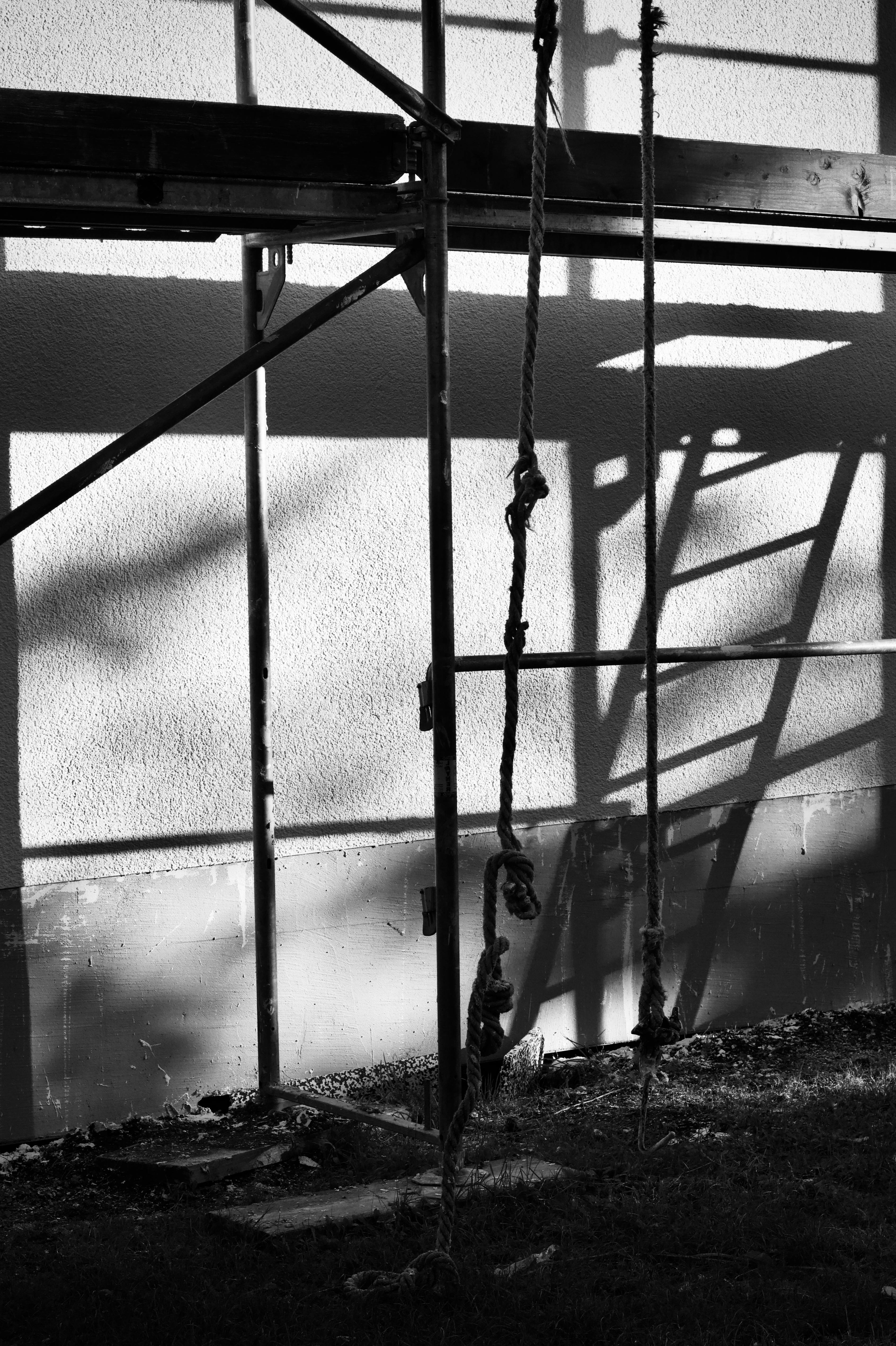 bezplatná Umělecká černobílá fotografie stínů lešení vrhaných na zeď. Základová fotografie