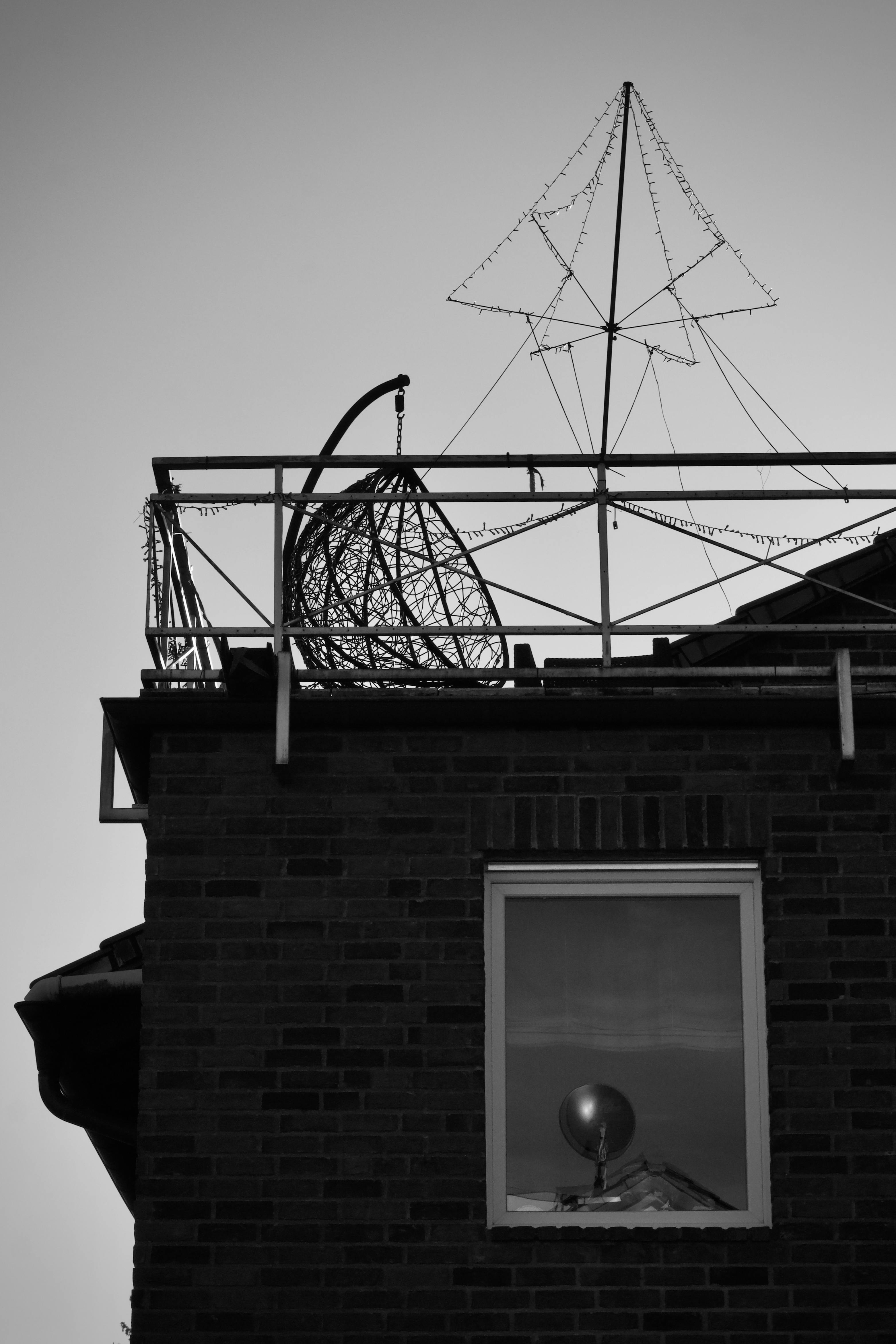 bezplatná Monochromatická fotografie střechy s geometrickými strukturami a odrazem v okně. Základová fotografie