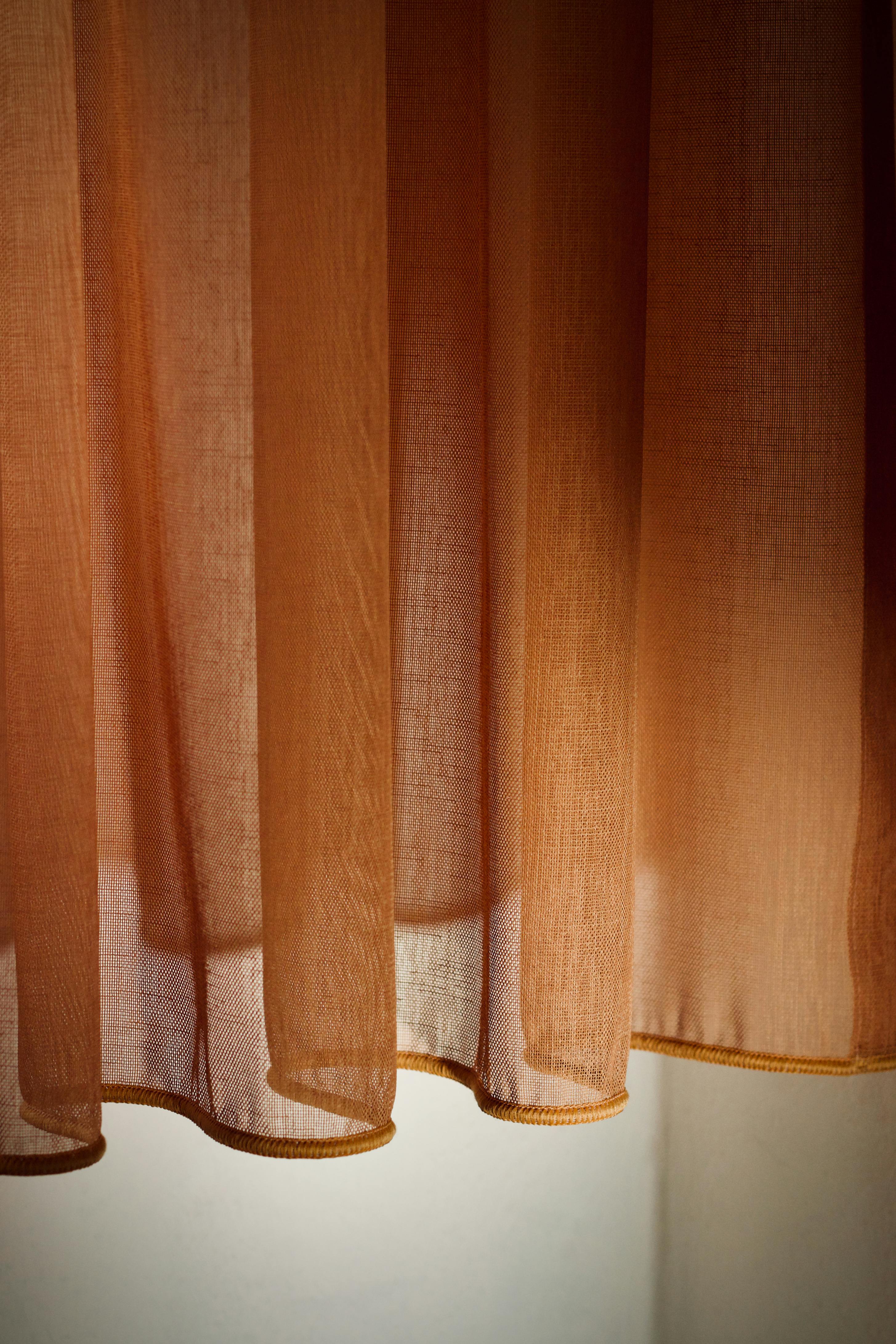 免费 特写镜头展现了透过薄薄的棕色窗帘洒进来的温暖光线。 素材图片