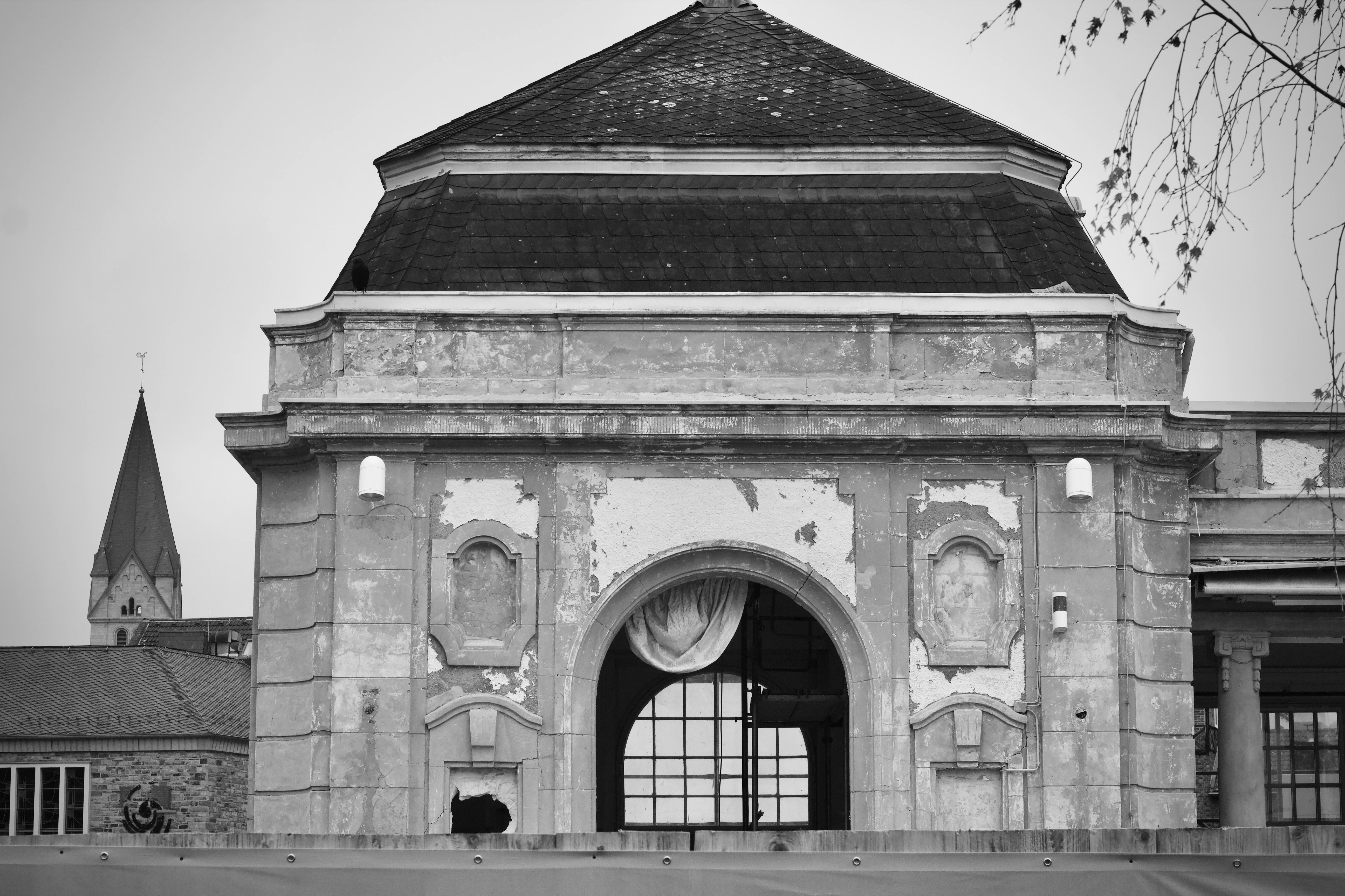 Gratuit Image en noir et blanc d'un bâtiment européen patiné par le temps, illustrant un style architectural historique. Photos