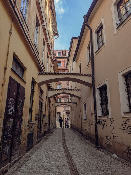 Free Charming narrow alley with arches and graffiti in the heart of Prague, Czech Republic. Stock Photo