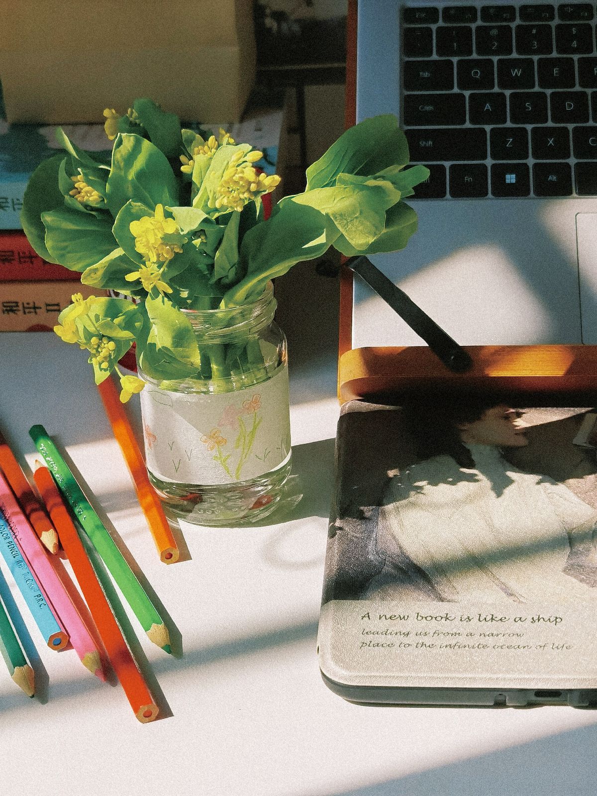 Bright desk with books flowers and a laptop for continuous self-education