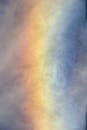 Vibrant Rainbow Spectrum in Cloudy Sky