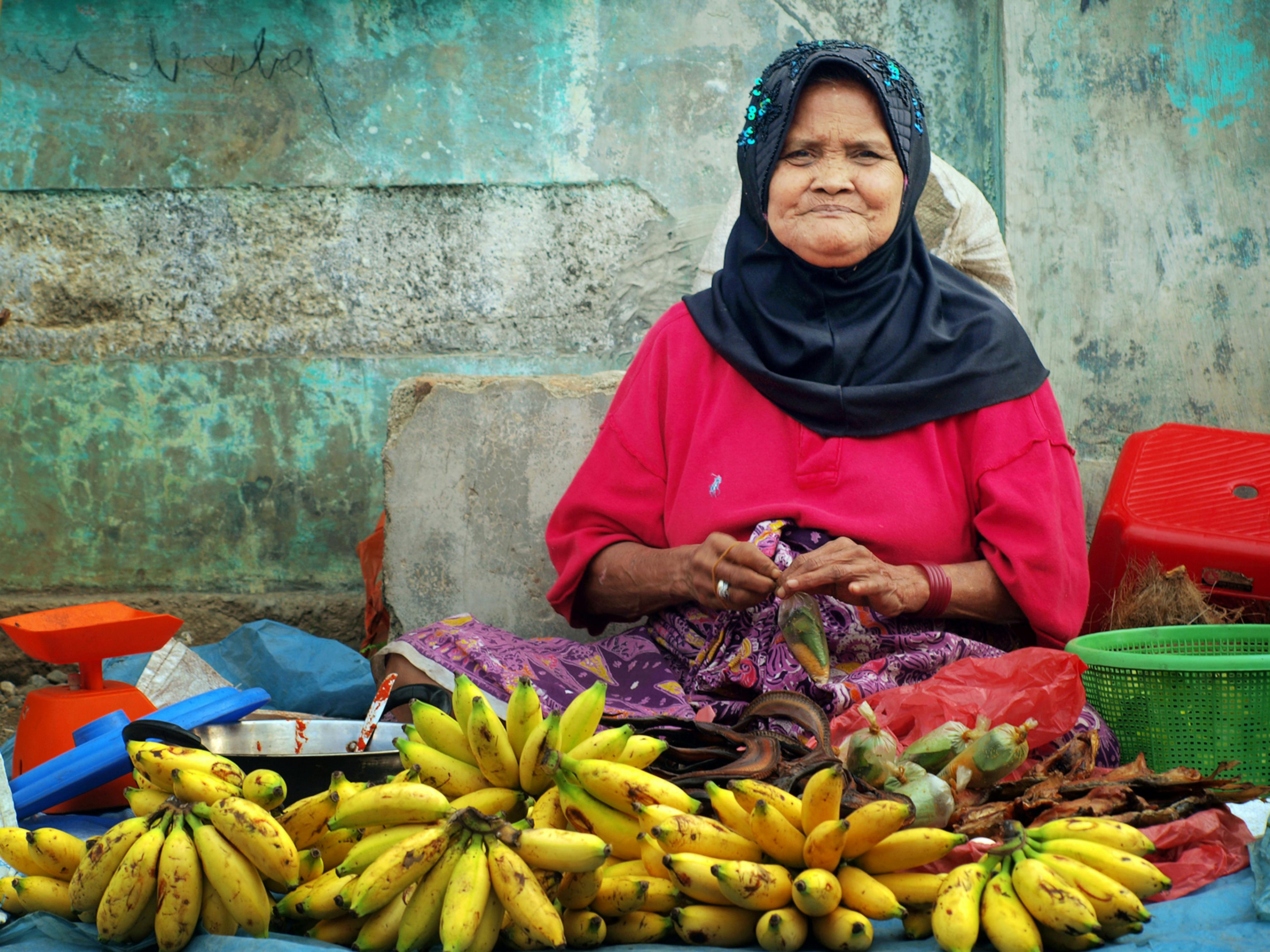 Gratis En eldre kvinne selger ferske bananer på et tradisjonelt marked i Nord-Sumatra, Indonesia. Arkivbilde