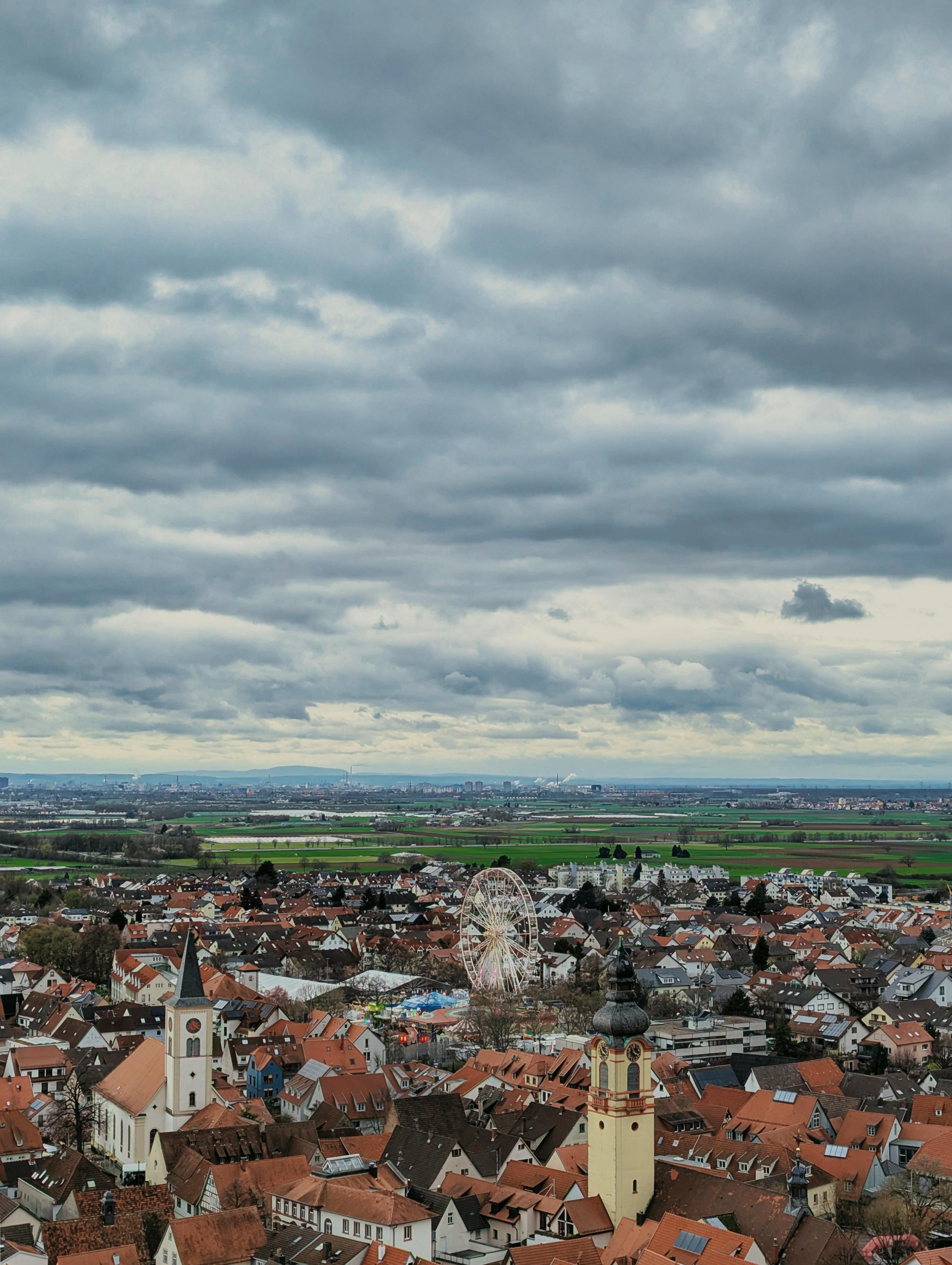 Gratuit Vue aérienne de Schriesheim, en Allemagne, montrant des bâtiments historiques et une grande roue sous un ciel nuageux. Photos
