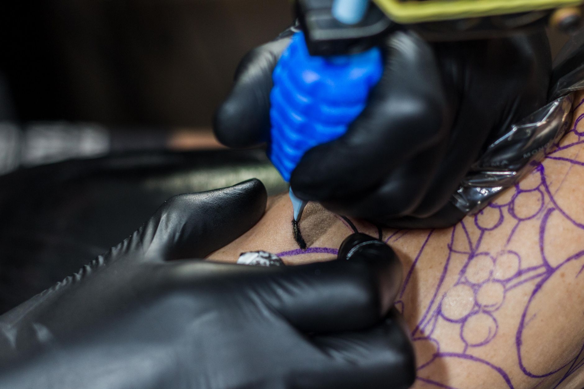 Réalisation d'un tatouage fine line minimaliste en salon, tracé au trait fin