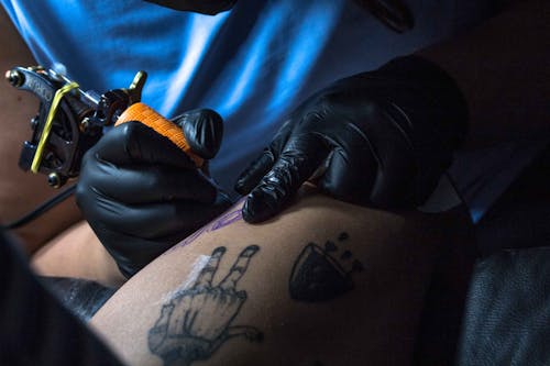 Close-up View Of A Person Tattooing Another Person