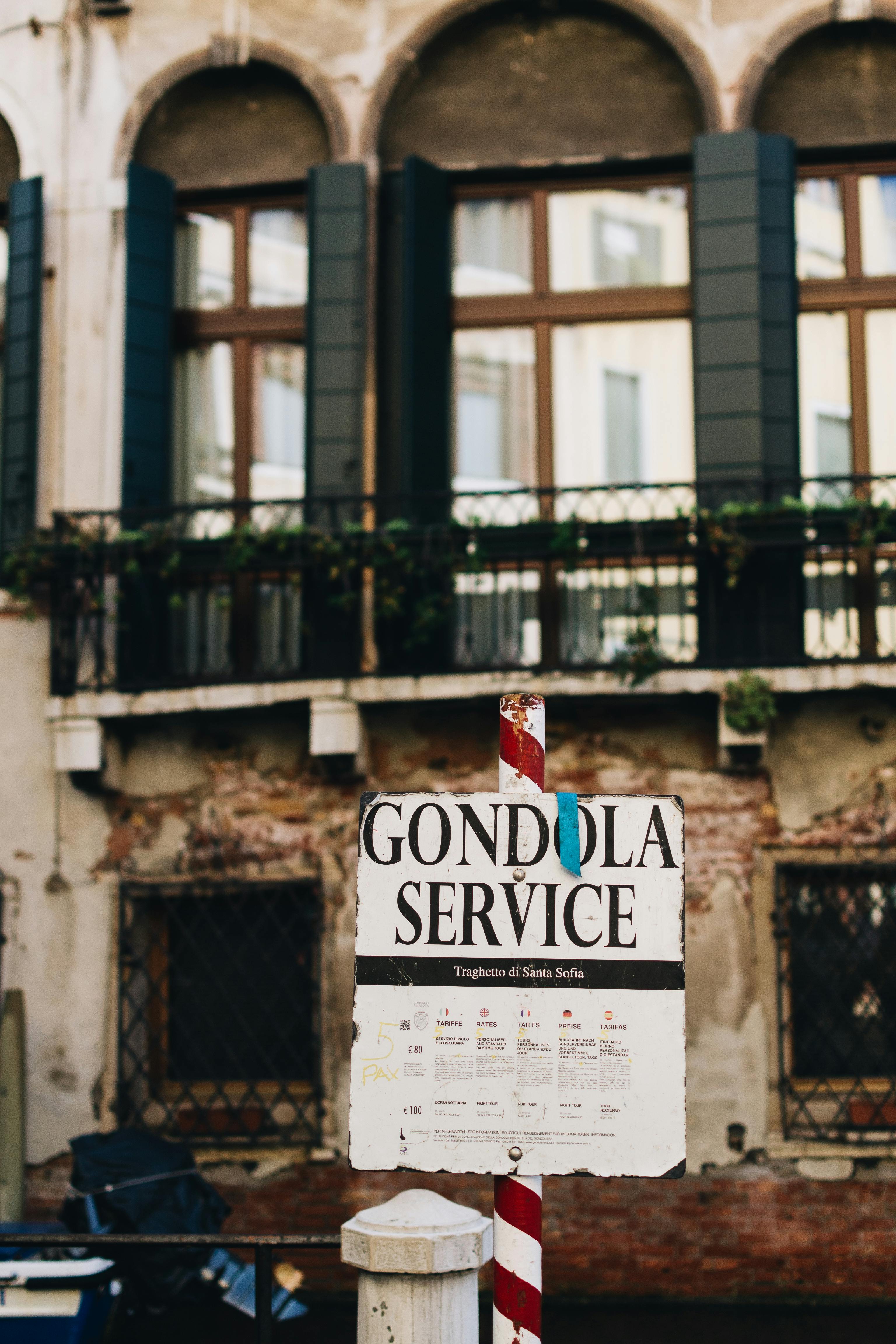 Kostenlos Gondel-Serviceschild vor rustikaler venezianischer Architektur in den Kanälen Venedigs. Stock-Foto