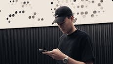 Young Man Checking Phone in Modern Urban Setting