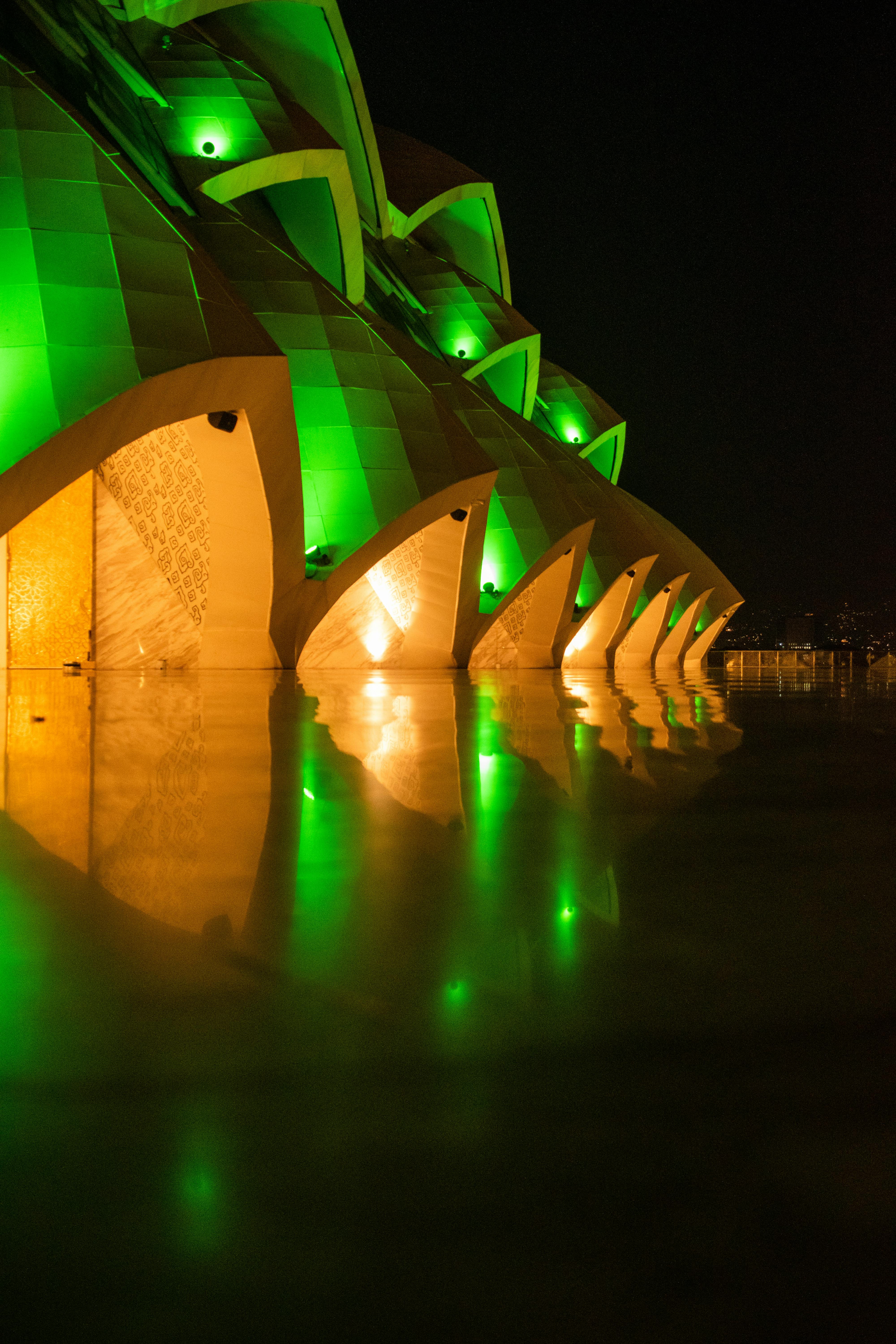 Gratis Impresionante vista nocturna de un edificio de arquitectura moderna iluminado con luces verdes. Foto de stock