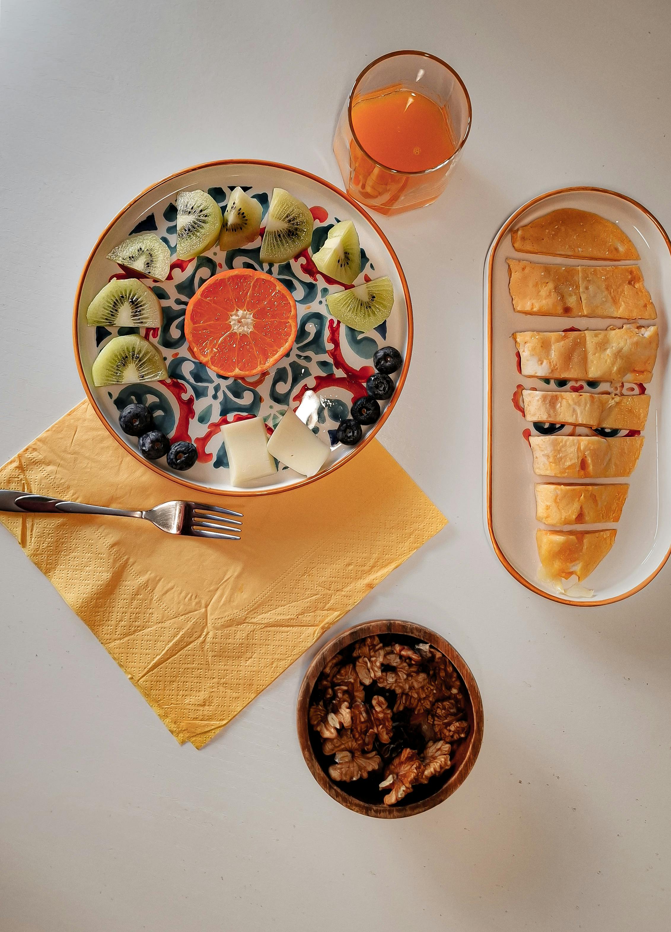Zadarmo Pohľad zhora na farebnú scenériu pre brunch s čerstvým ovocím, pomarančovým džúsom a pečivom. Fotka z fotobanky
