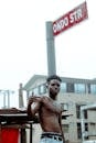 Photo Of Topless Man Standing Beside Post