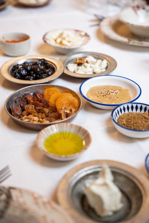 Free Delicious spread of Turkish breakfast featuring olives, dates, cheeses, and more on a traditional table setting. Stock Photo