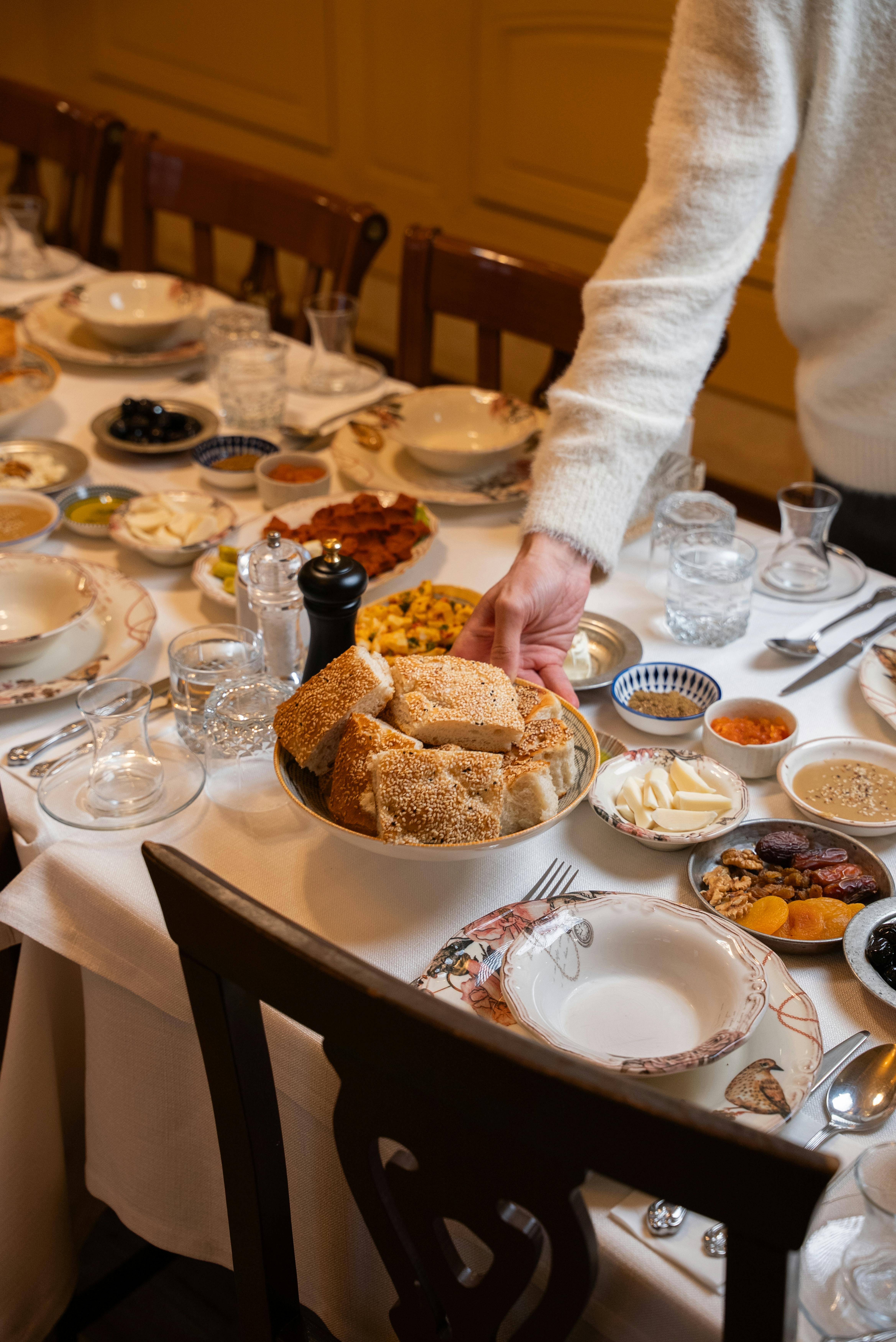 無料 屋内の素敵な空間に、伝統的なトルコ料理とパンが美しく盛り付けられたテーブル。 写真素材