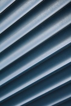 Abstract photo of a metallic ribbed surface with cool tones and industrial feel.