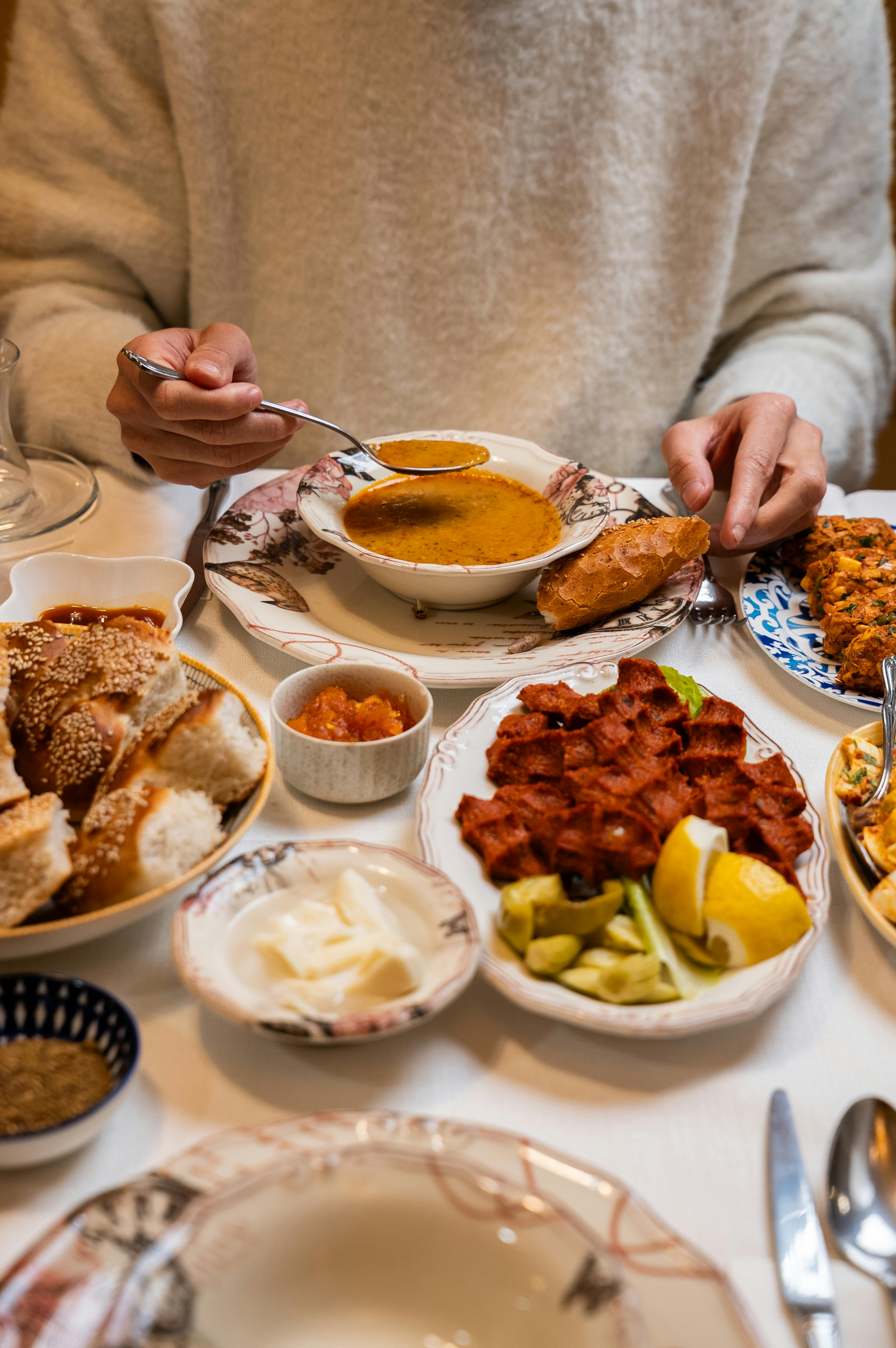 grátis Uma mesa posta com pratos tradicionais turcos, incluindo sopa, pão e meze, em Gaziantep. Foto profissional