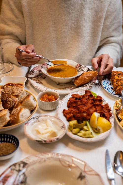 Free A table set with traditional Turkish dishes featuring soup, bread, and meze in Gaziantep. Stock Photo