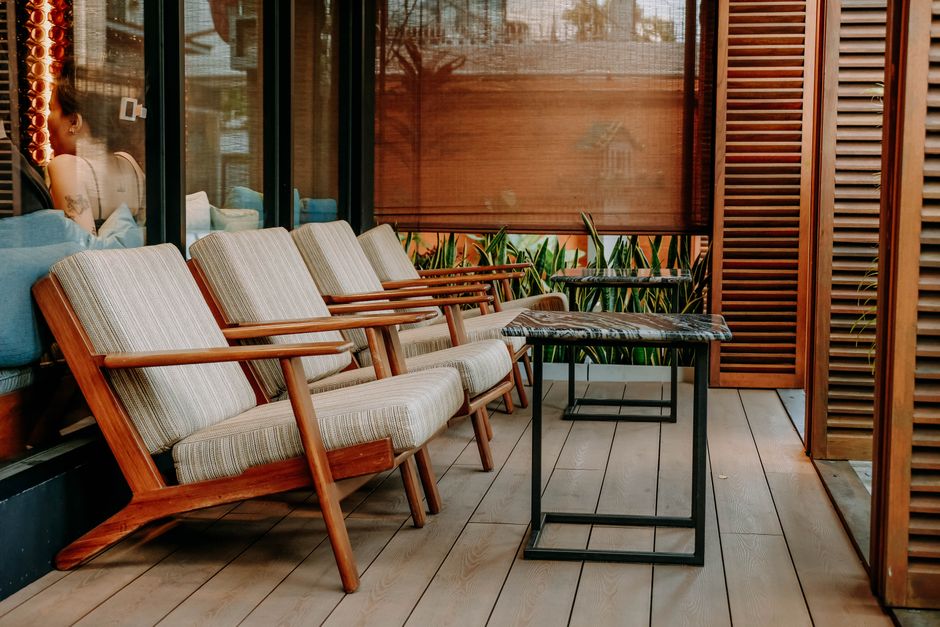 Inviting outdoor patio area with wooden chairs and tables, perfect for relaxation in a chic setting.