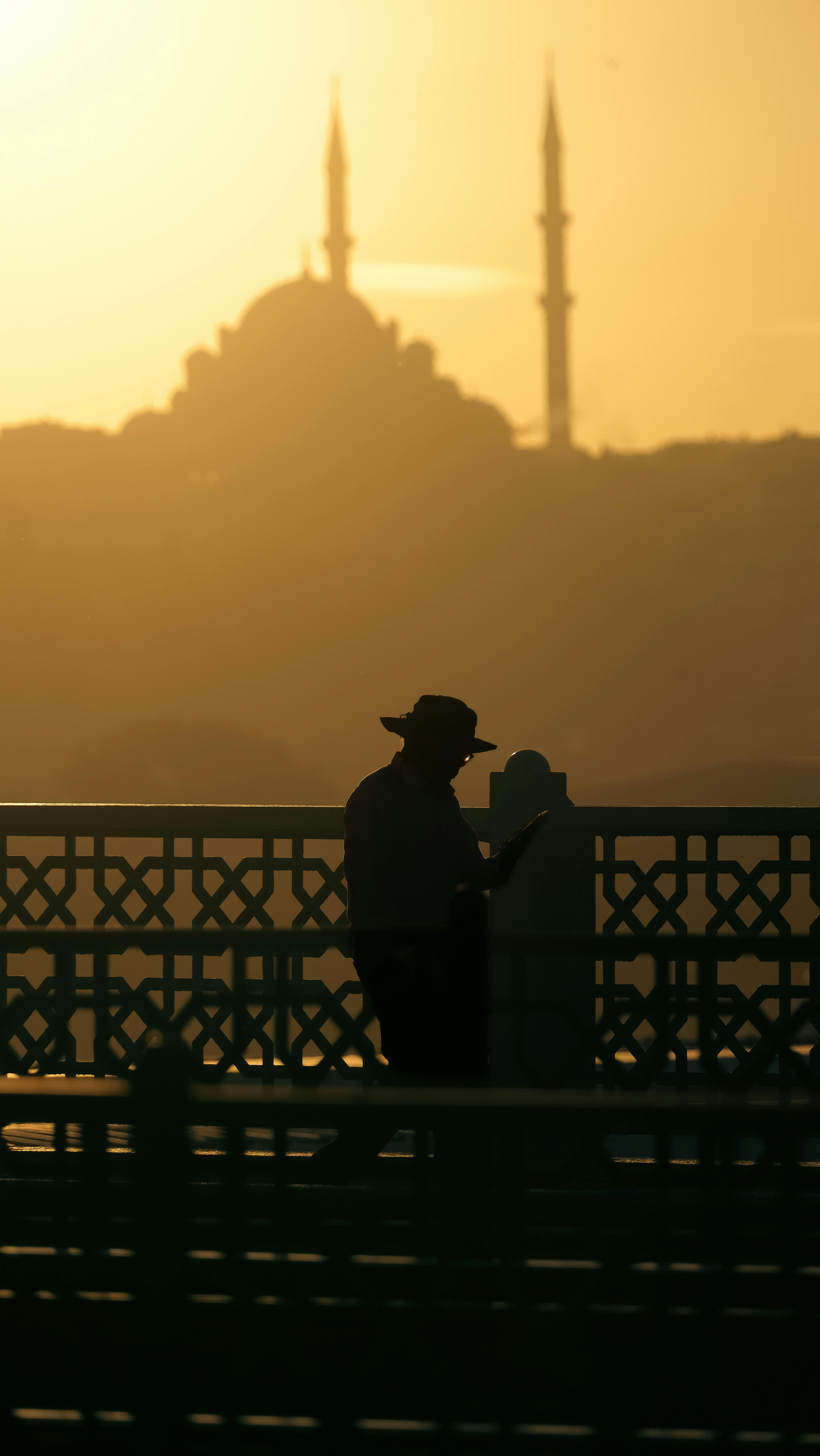 Kostenlos Silhouette einer Person auf der Galatabrücke mit Blick auf Istanbul und eine Moschee bei Sonnenuntergang. Stock-Foto