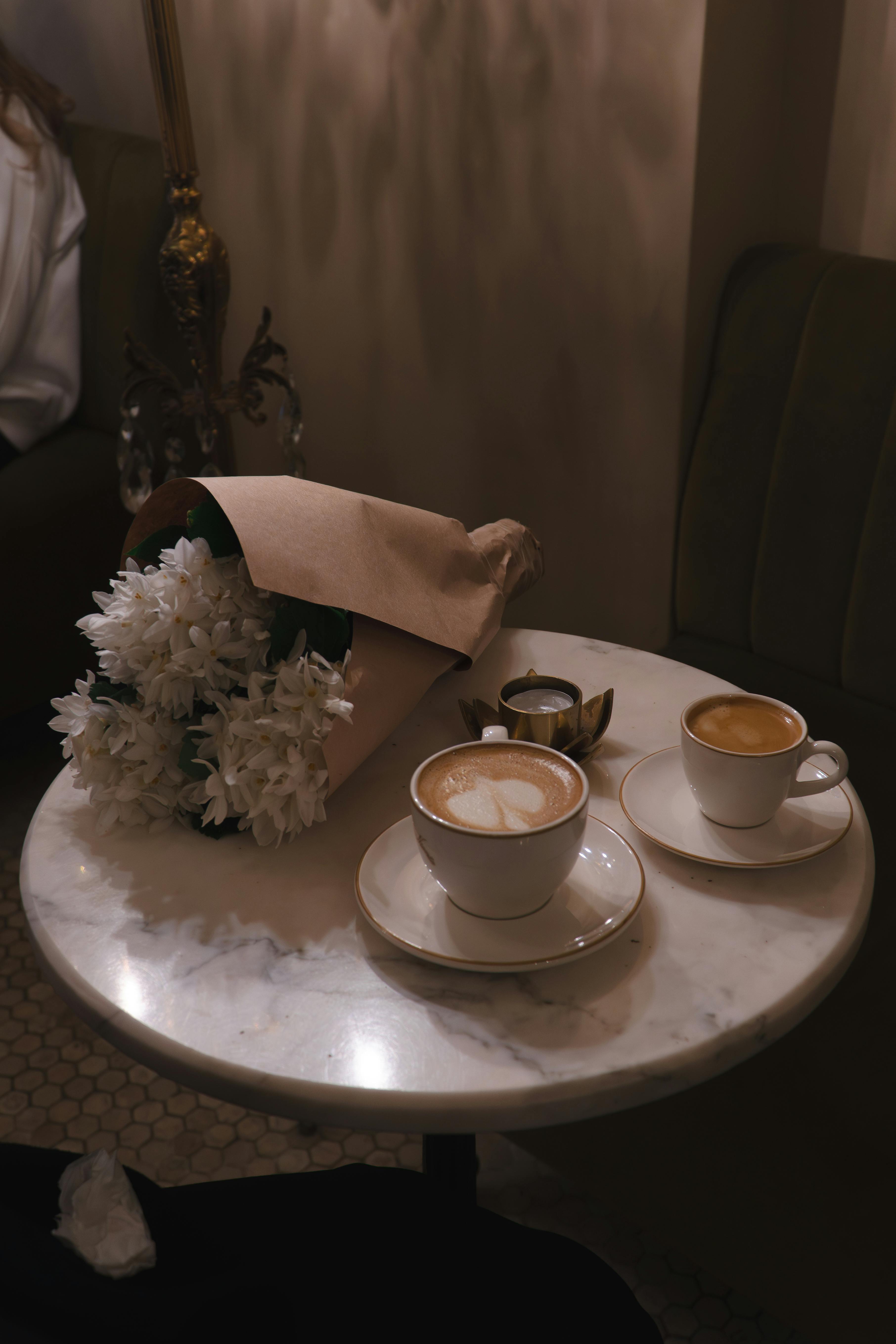 Kostnadsfria En charmig kaféscen i Istanbul med ett marmorbord med kaffe och blommor, som utstrålar en varm och inbjudande atmosfär. Stock foto