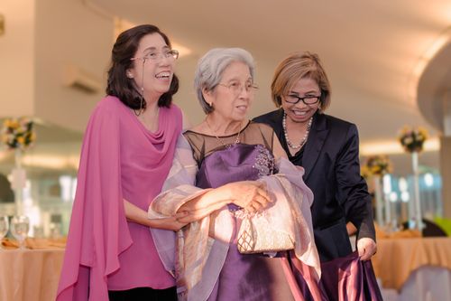 Free Three elegantly dressed women share a joyful moment indoors at a family celebration or event. Stock Photo