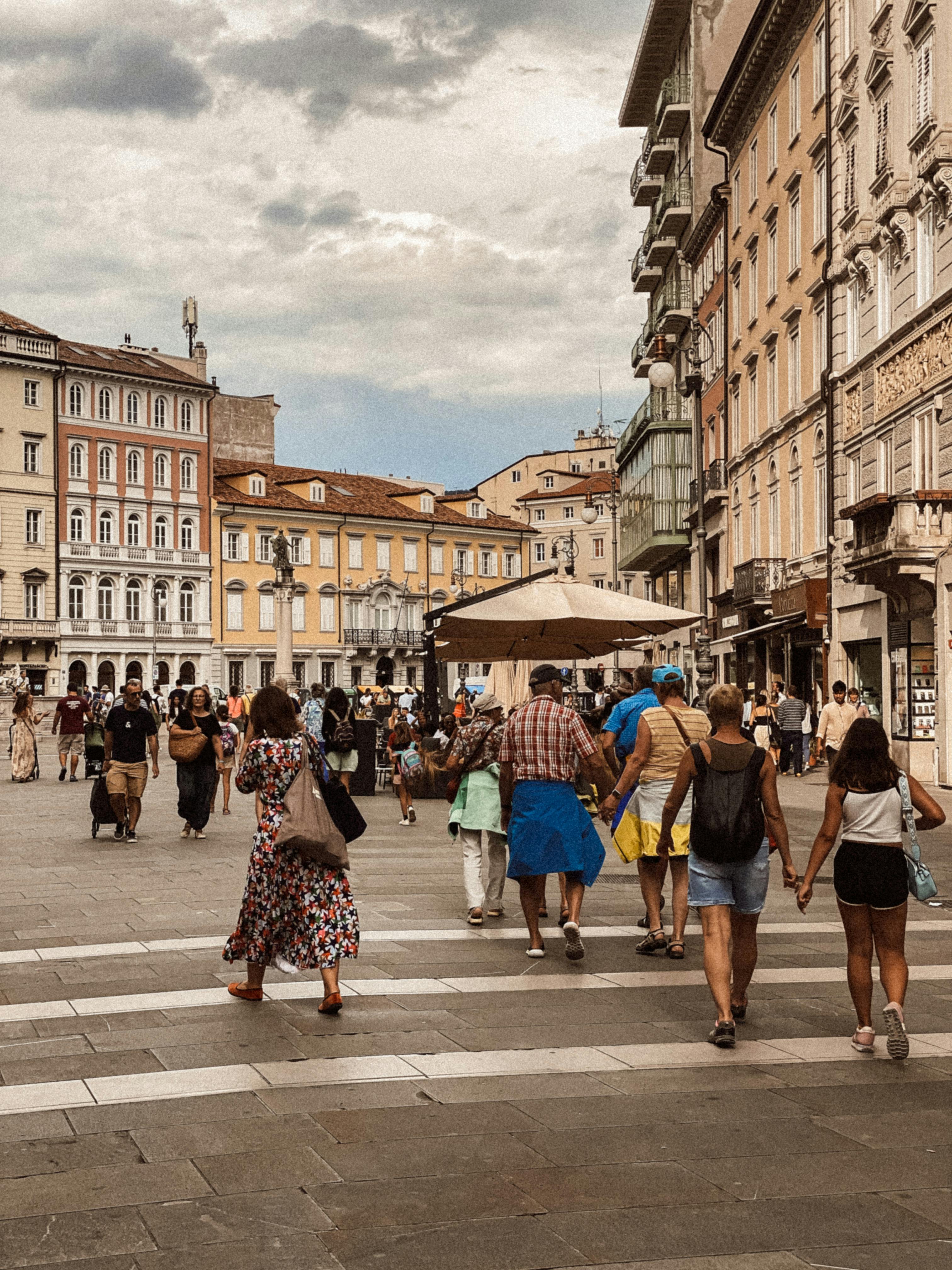Δωρεάν Πολυσύχναστη ιταλική πλατεία με ποικίλους ανθρώπους που απολαμβάνουν μια ηλιόλουστη καλοκαιρινή μέρα, περιτριγυρισμένη από κλασική αρχιτεκτονική. Φωτογραφία από στοκ φωτογραφιών