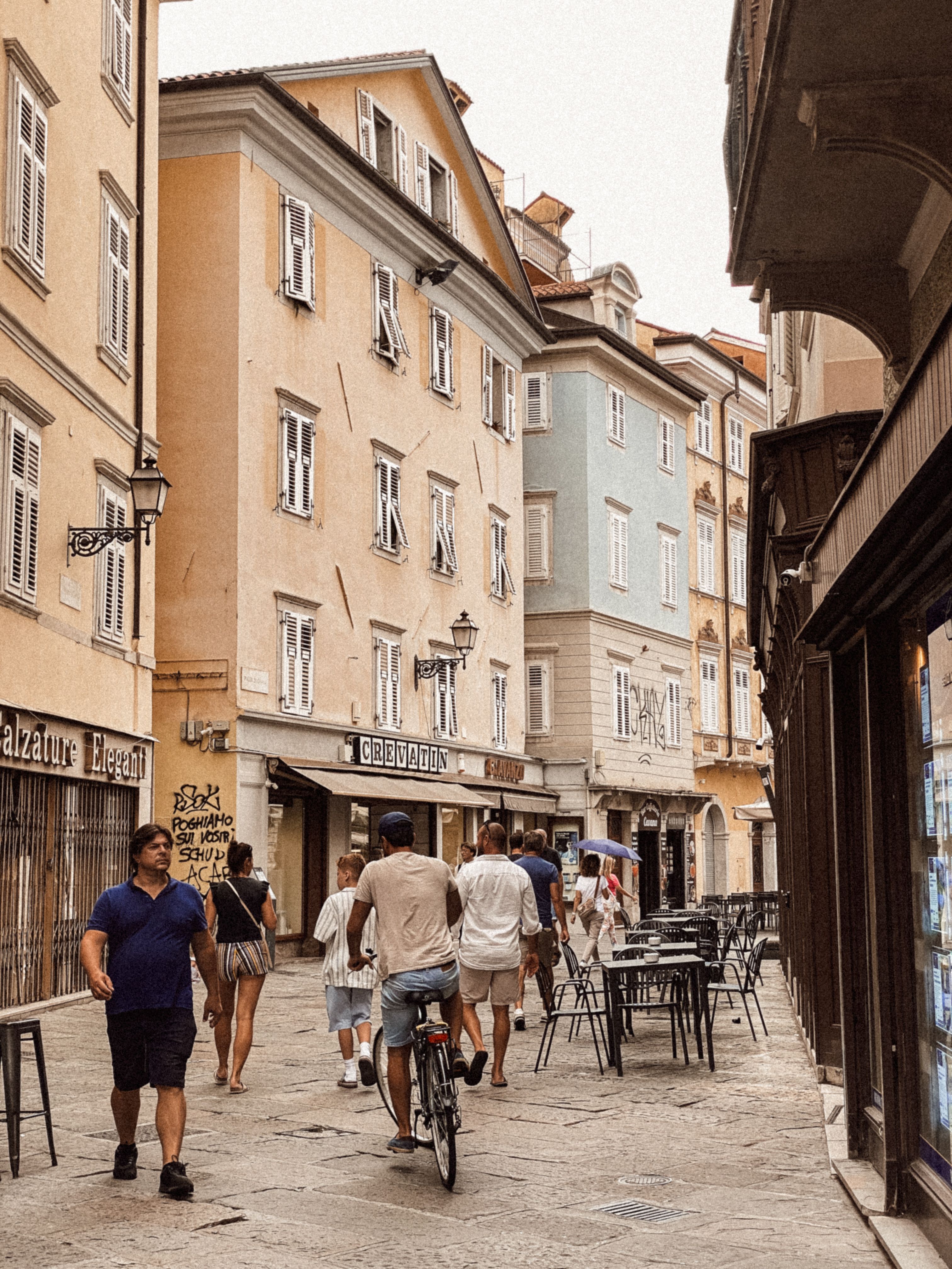 Bustling Italian city street with historic architecture and casual pedestrians, perfect for travel inspiration.