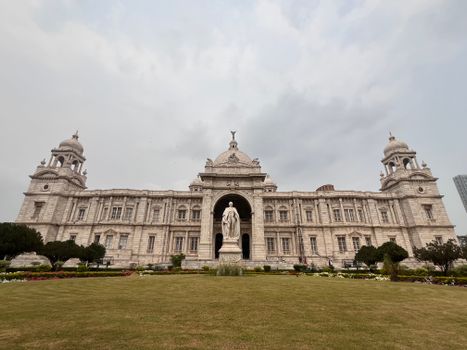 A frontal view of Victoria Memorial in Kolkata, India, under cloudy skies.