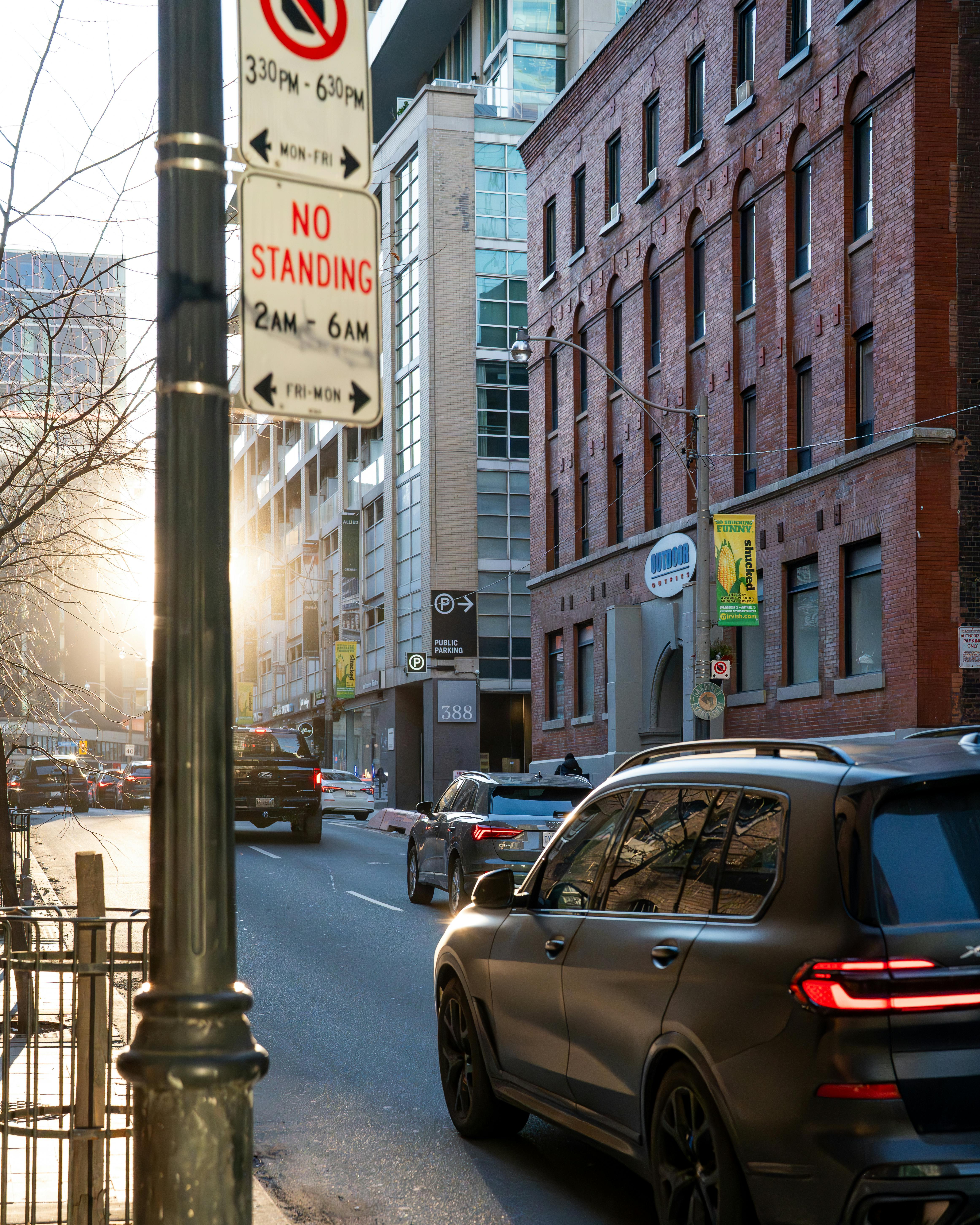 Gratis Vivace scena di strada nel centro di Toronto, con il sole che tramonta dietro edifici moderni e traffico. Foto a disposizione
