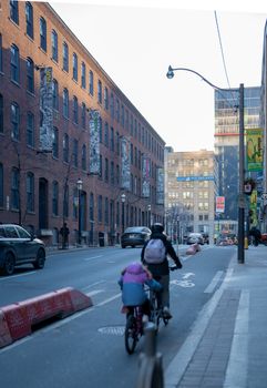A person biking on a downtown Toronto street, showcasing urban everyday life.