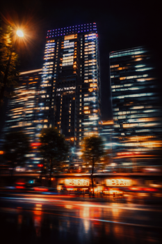 Vibrant night view of Tokyo skyscrapers in Chiyoda, with light trails reflecting city energy.