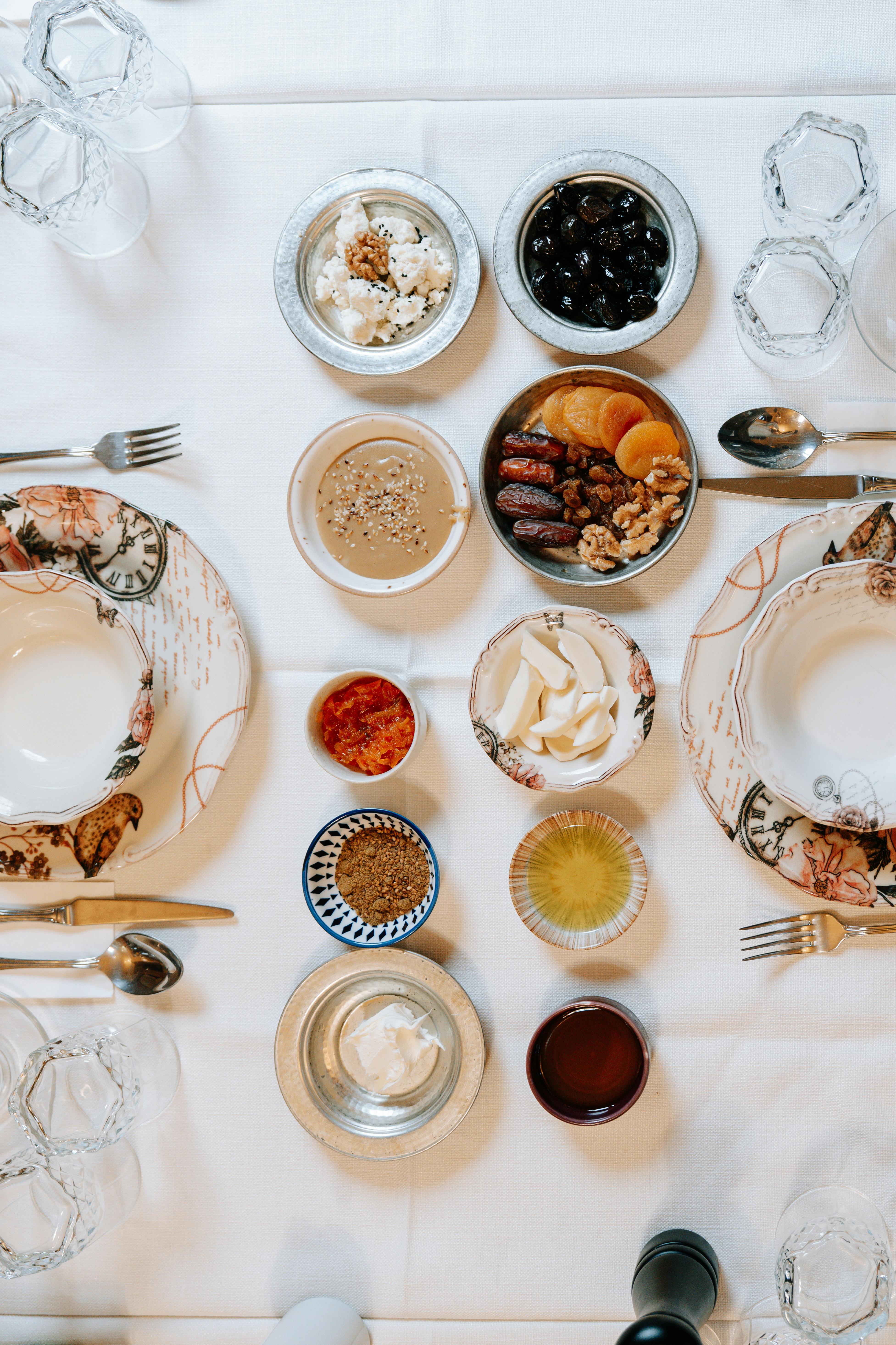 Gratuit Vue en plongée d'une table à manger élégante dressée avec divers amuse-bouche dans des plats raffinés. Photos