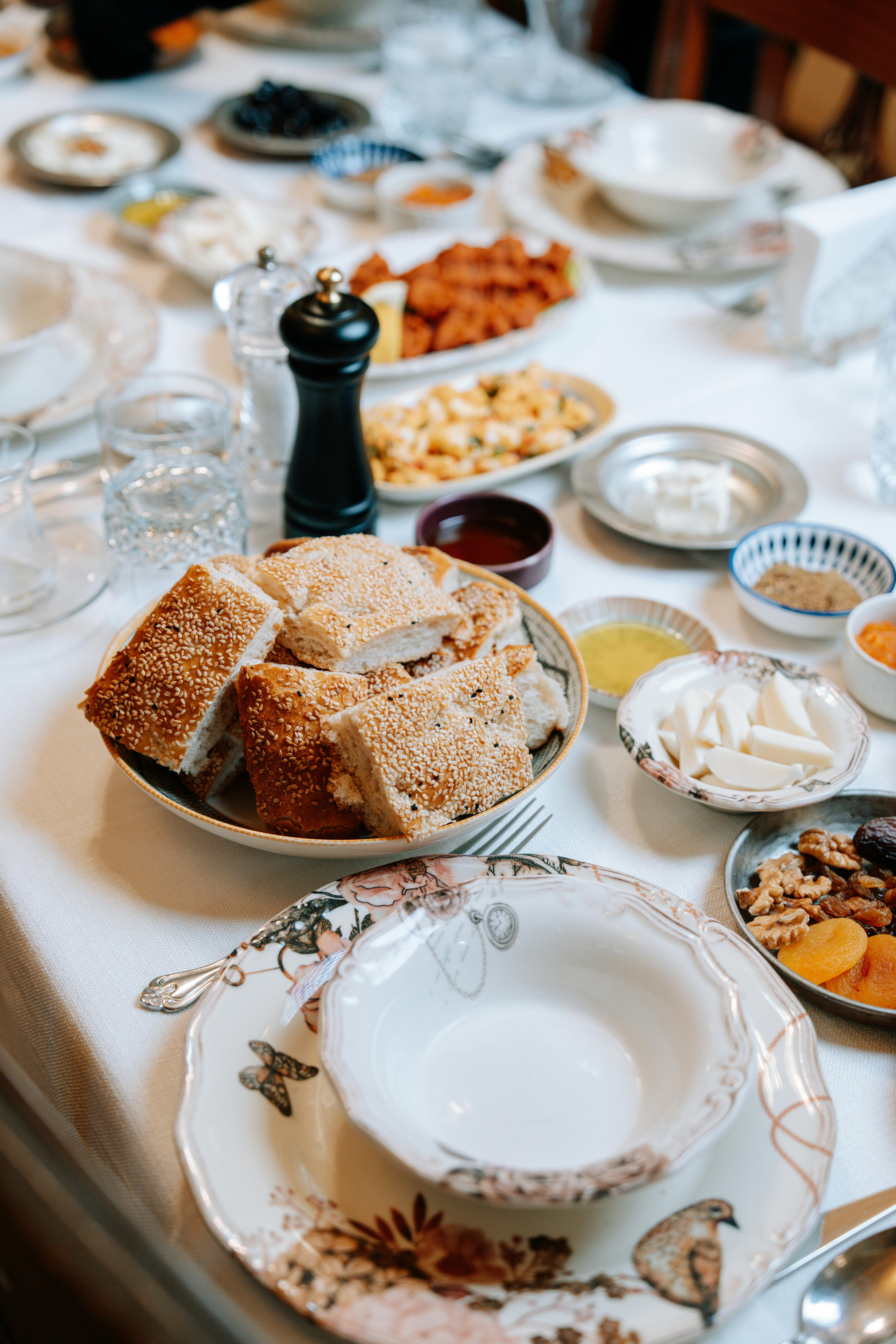 Kostenlos Ein üppiges Festtagsbuffet mit frisch gebackenem Brot, Nüssen, Dips und vielem mehr auf einem wunderschön gedeckten Tisch. Stock-Foto