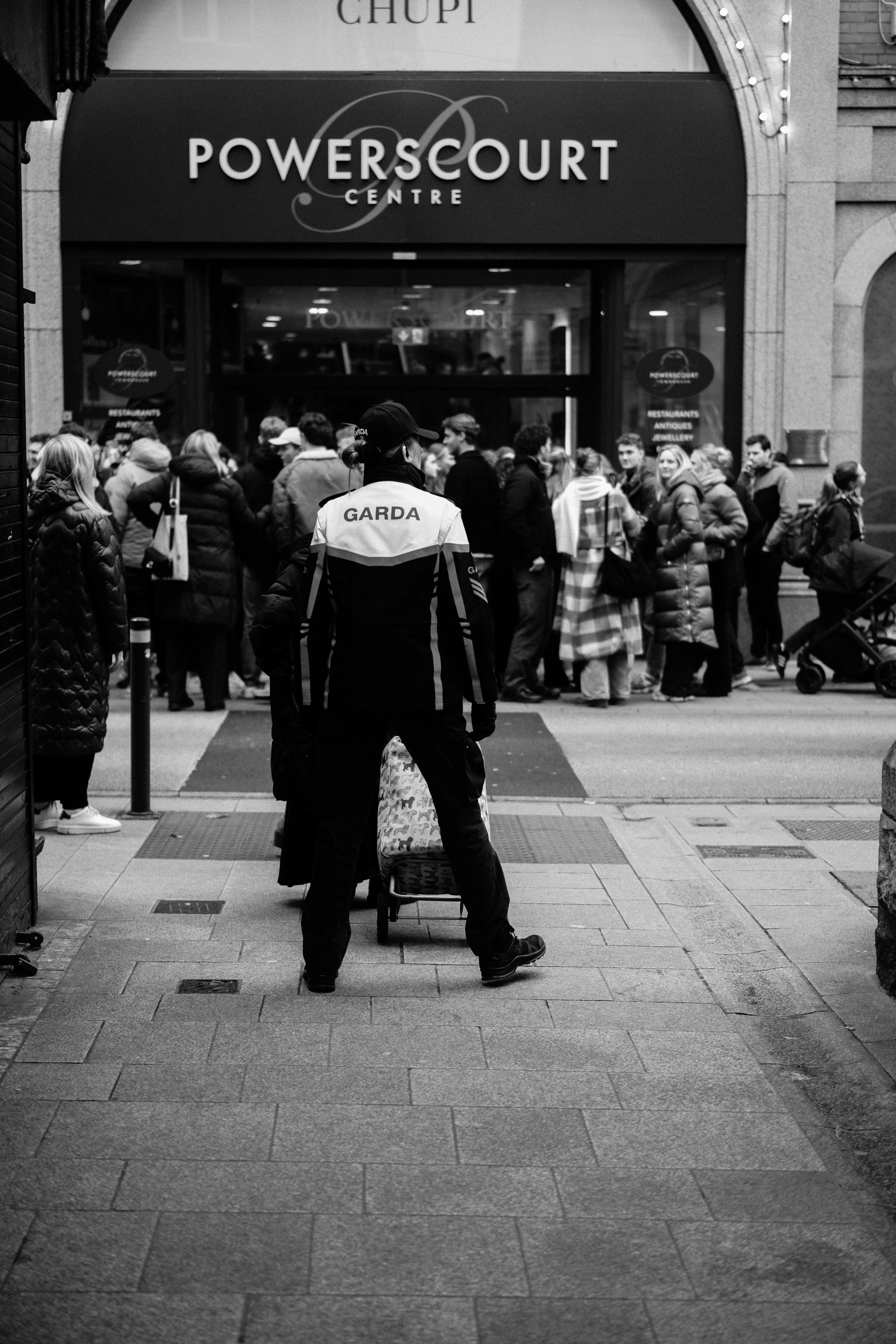 grátis Cena de rua em preto e branco mostrando um agente da Garda em frente ao Powerscourt Centre, em Dublin, Irlanda. Foto profissional