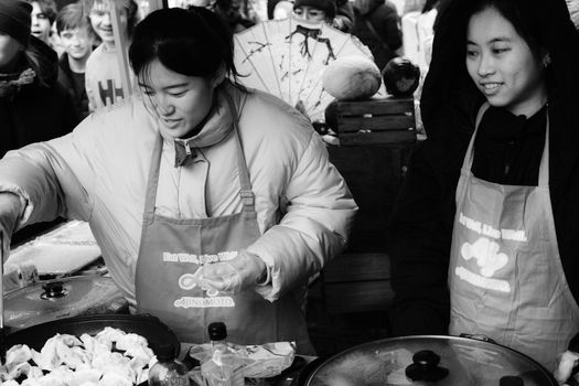 Street food scene in Dublin market showing vendors making dumplings, capturing vibrant city life.