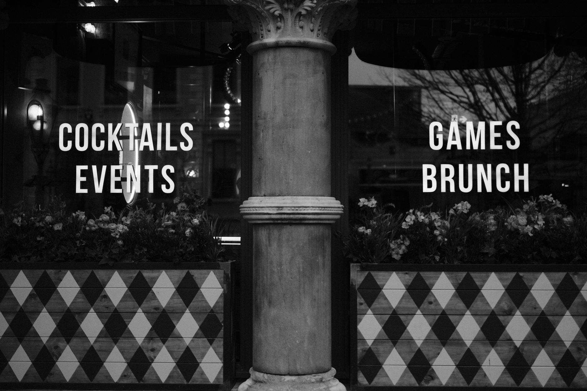 Black and white image of a Dublin bar with decorative signage and floral decor.